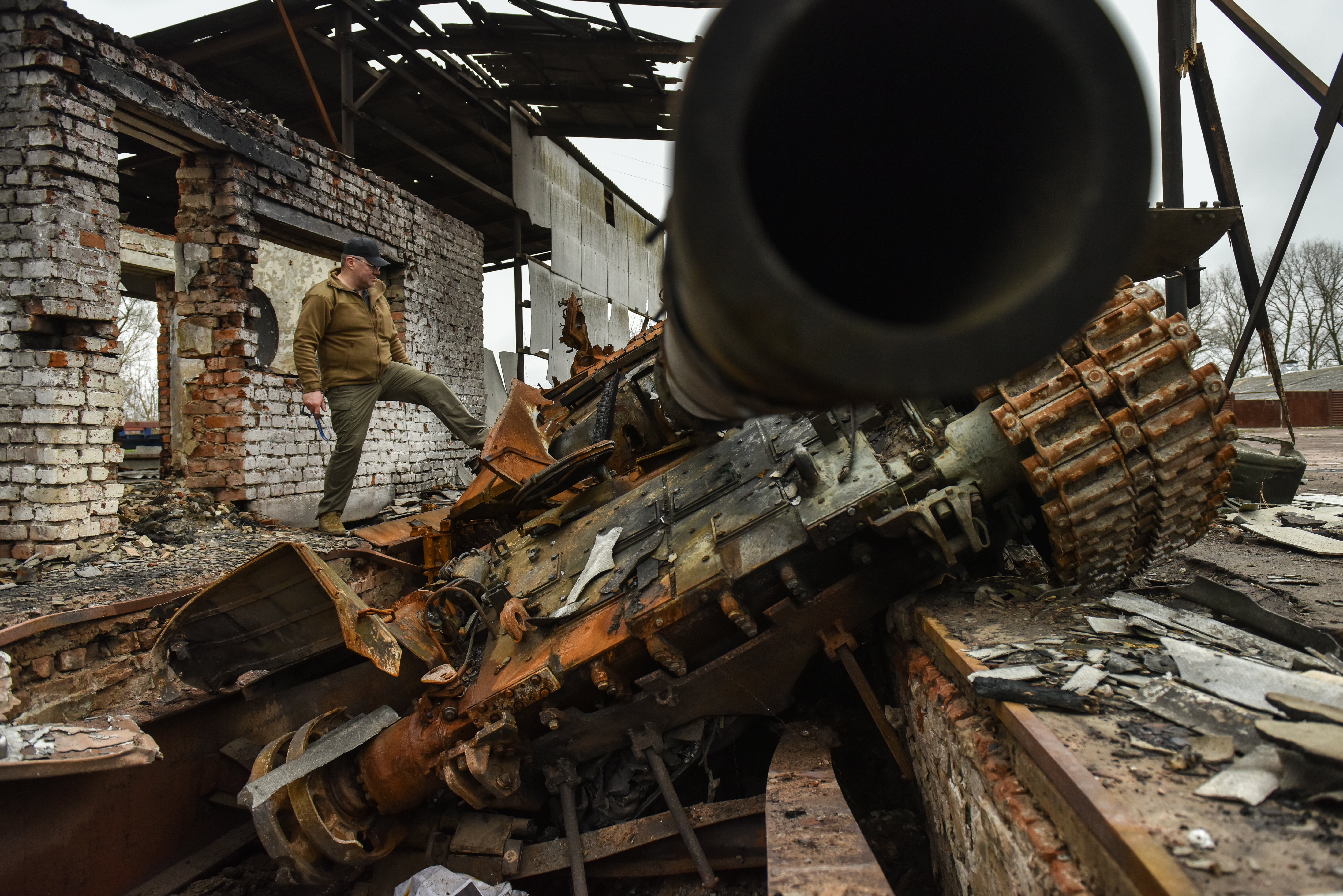 A man explores a destroyed tank in Ivanivka village, Chernihiv