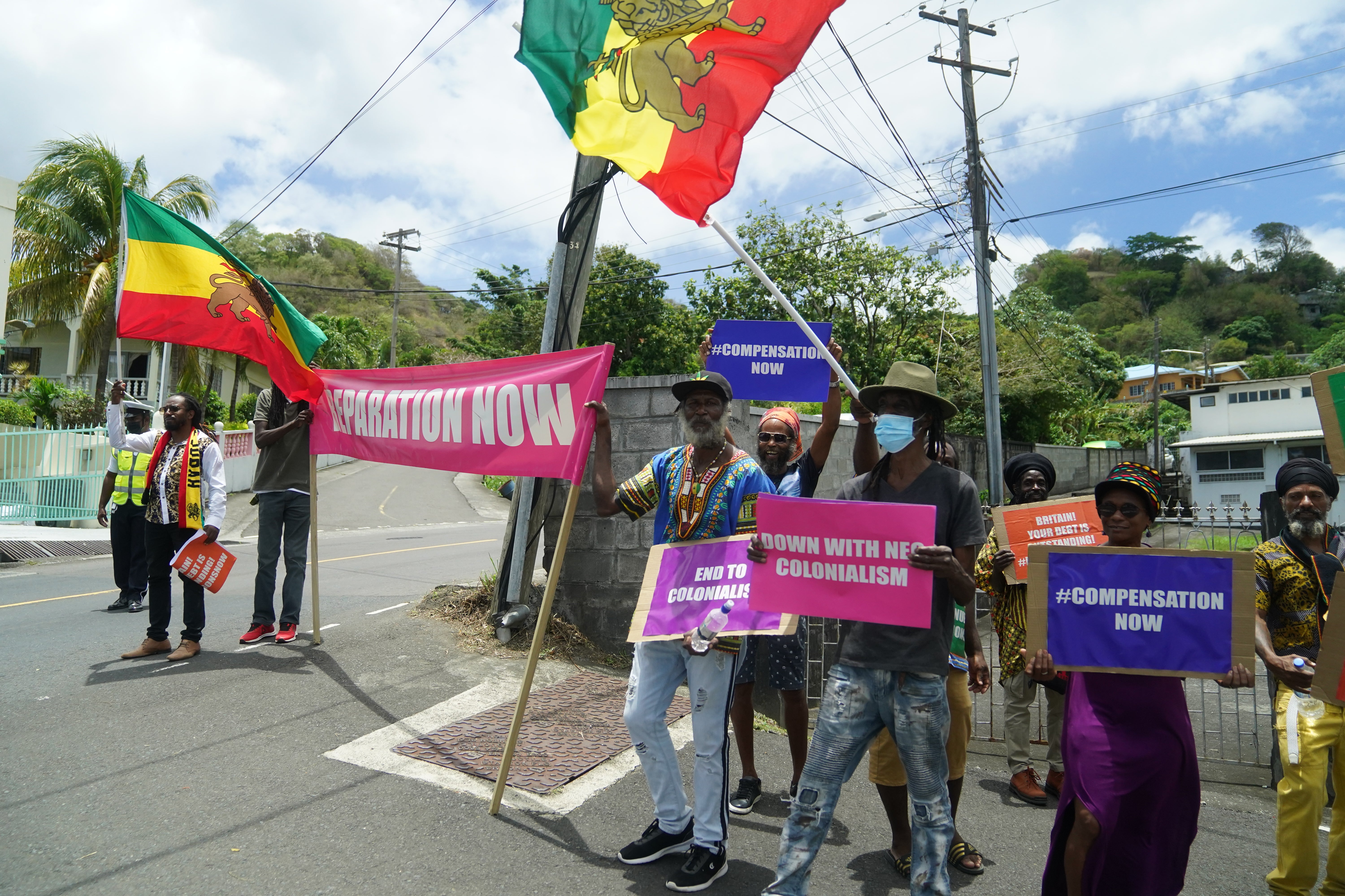 Protesters with with banners protesting against British colonialism as the Earl and the Countess of Wessex arrive at Government House in St Vincent and the Grenadines