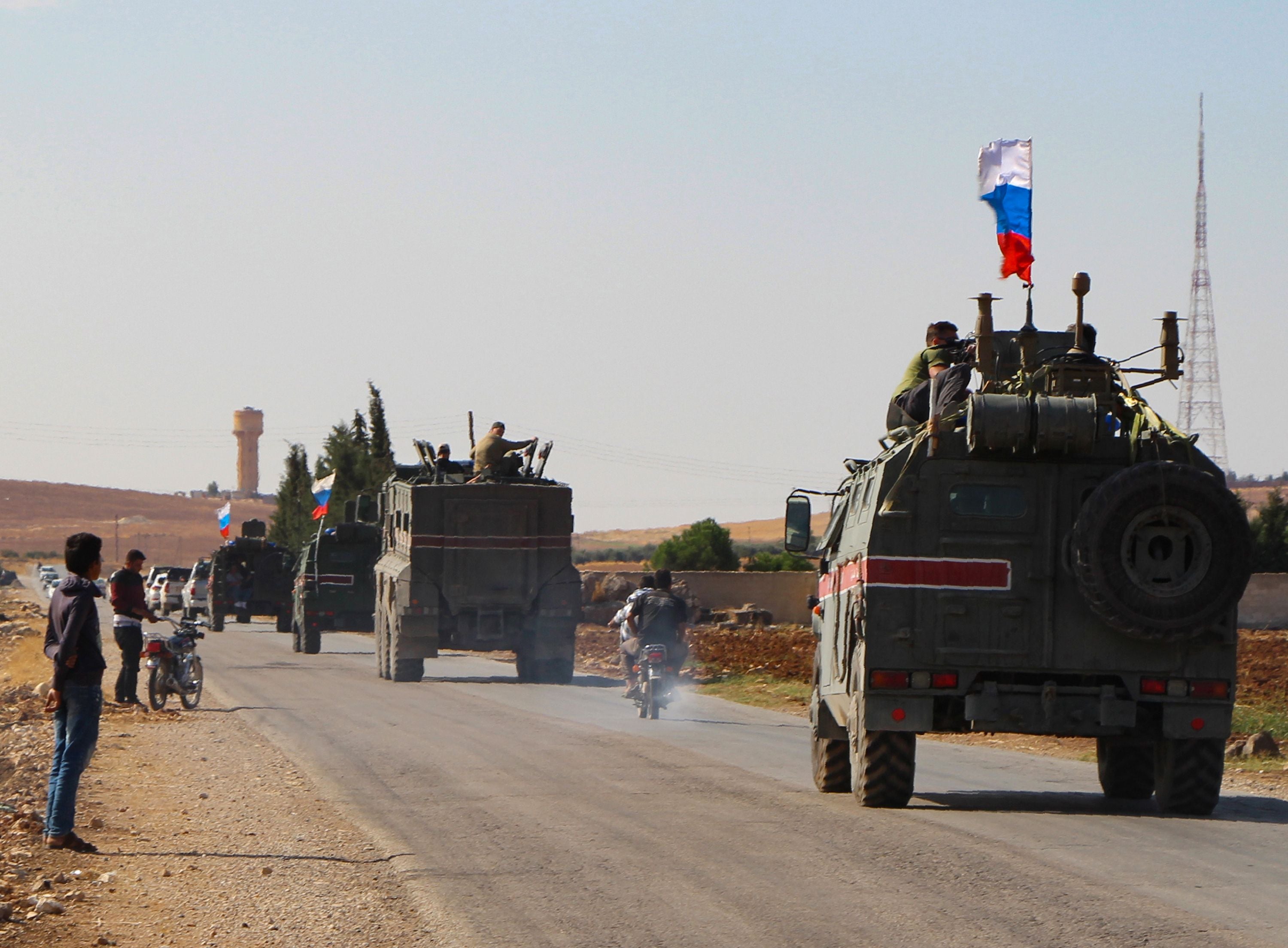 A convoy of Russian military vehicles drives toward the northeastern Syrian city of Kobane in 2019