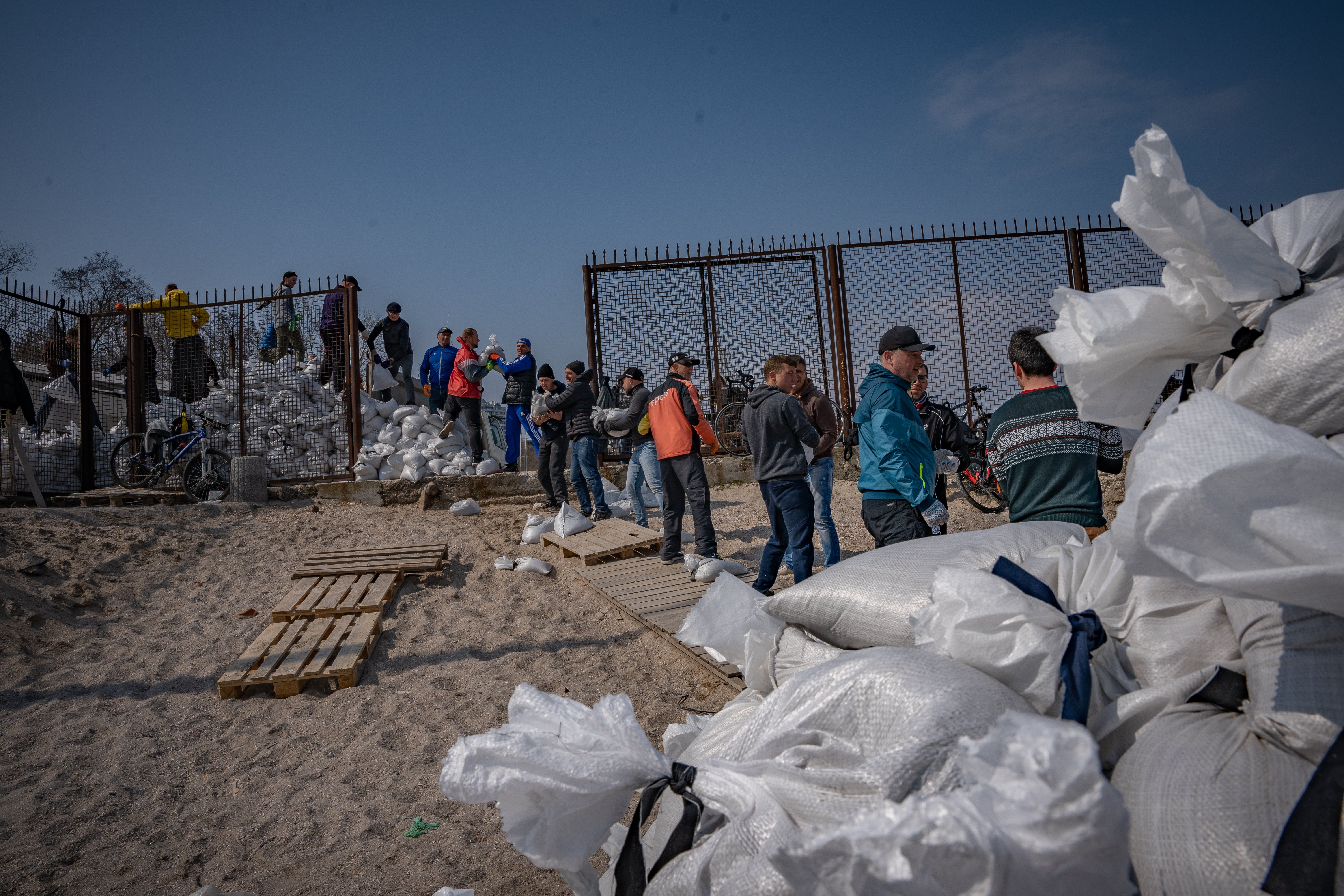 Volunteers make sandbags on the beach in Odessa