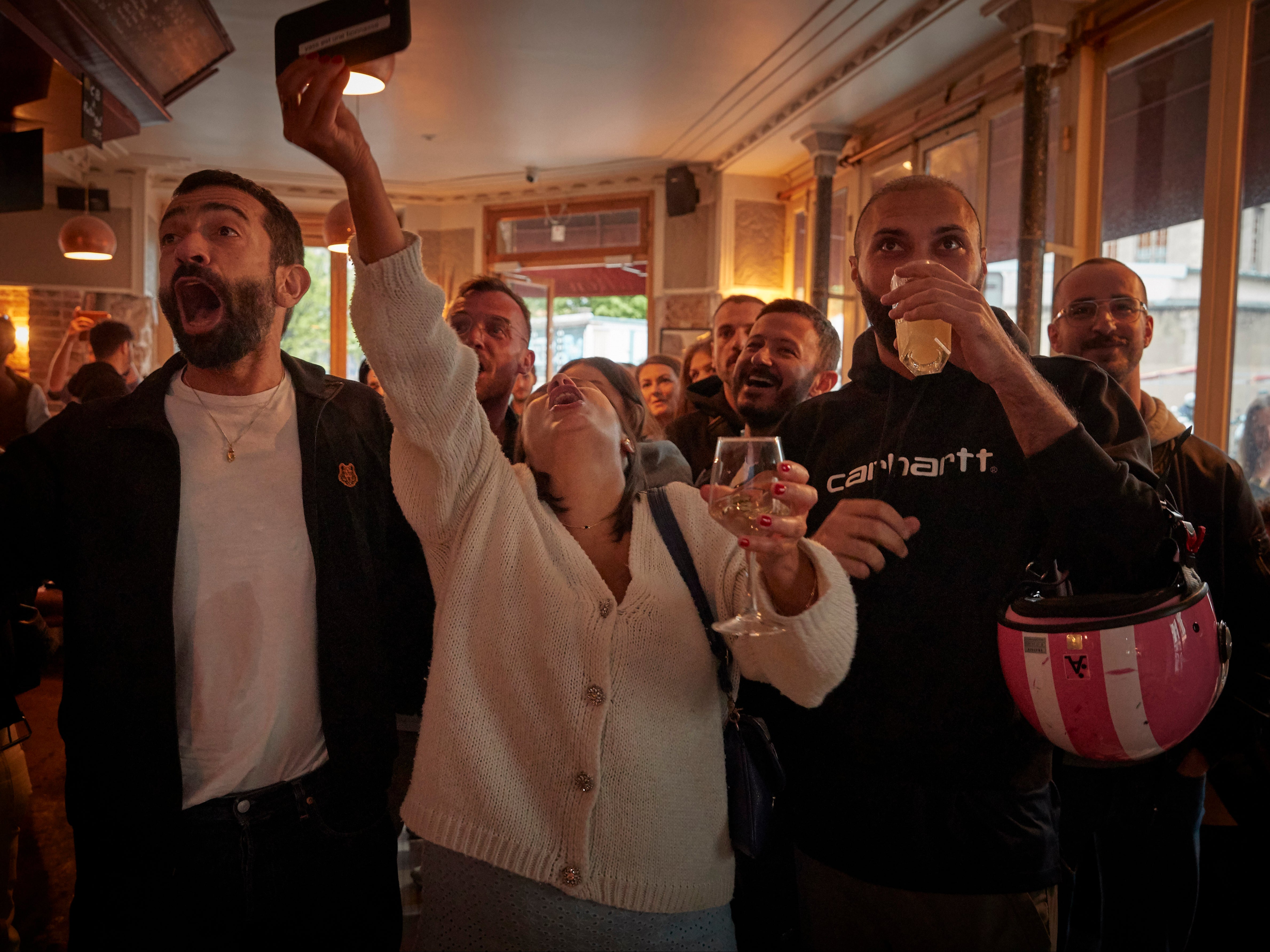 Parisians celebrate in Le Carillon, a scene of the November 13th terrorist attacks, as France's centrist incumbent president Emmanuel Macron beats his far-right rival Marine Le Pen for a second five-year term