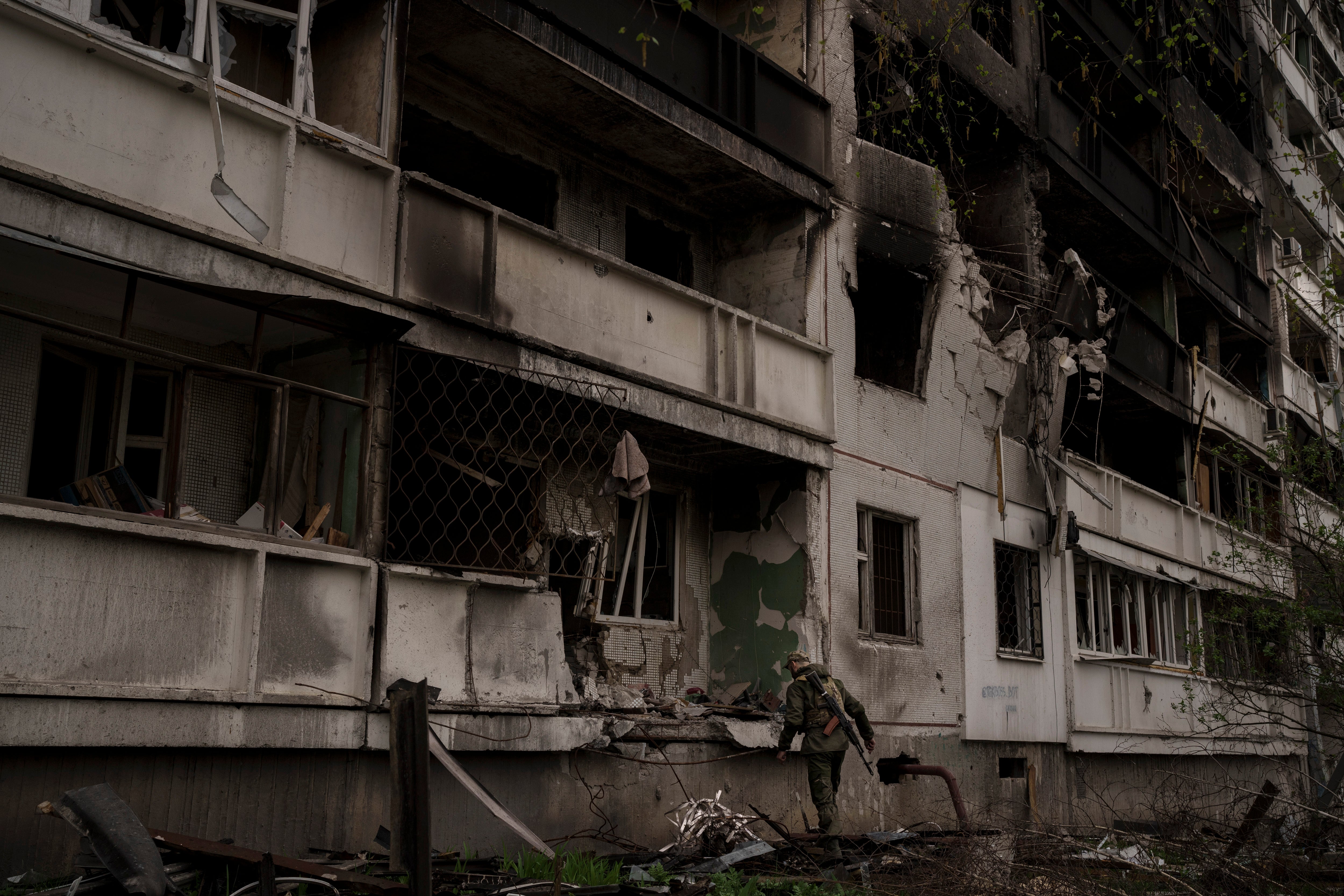 A Ukrainian serviceman inspects a heavily damaged apartment building after Russian bombardment in Kharkiv