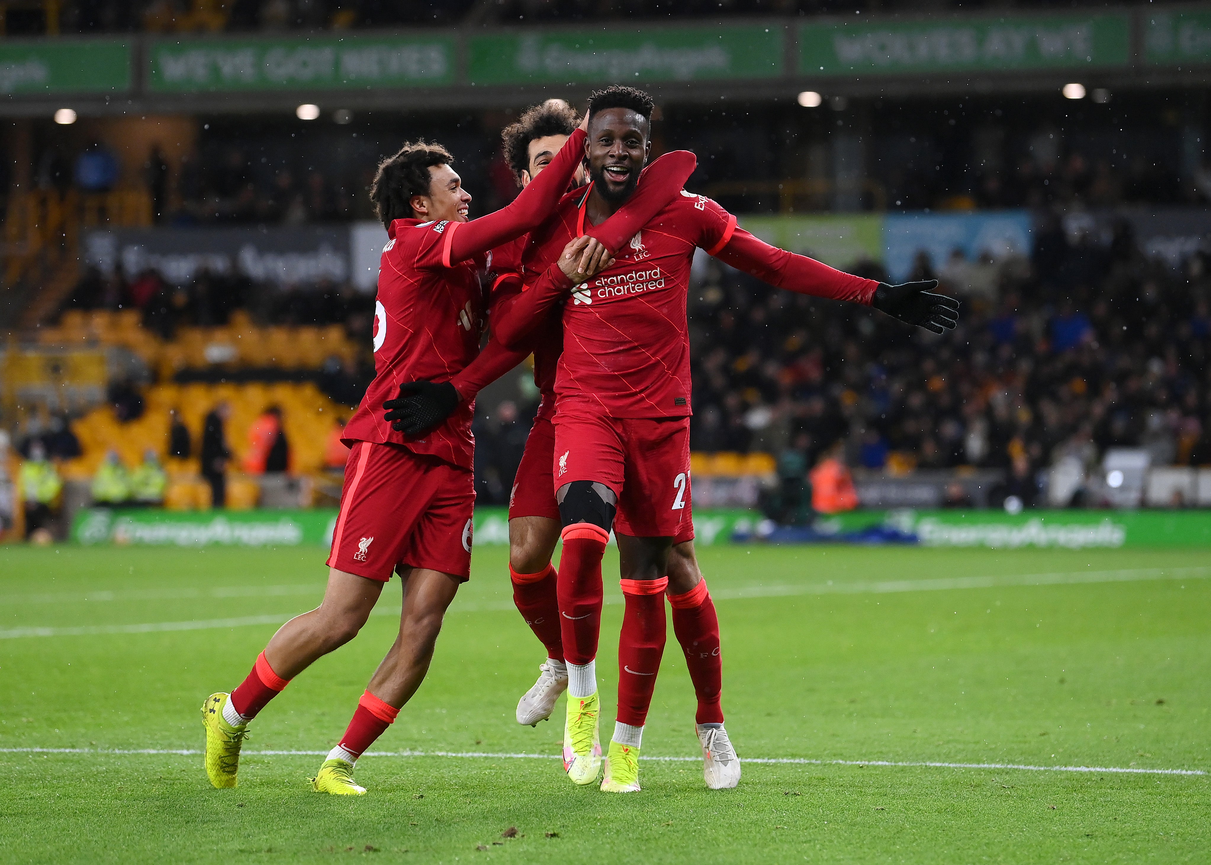 Divock Origi of Liverpool celebrates with Trent Alexander-Arnold and Mohamed Salah after scoring at Molineux