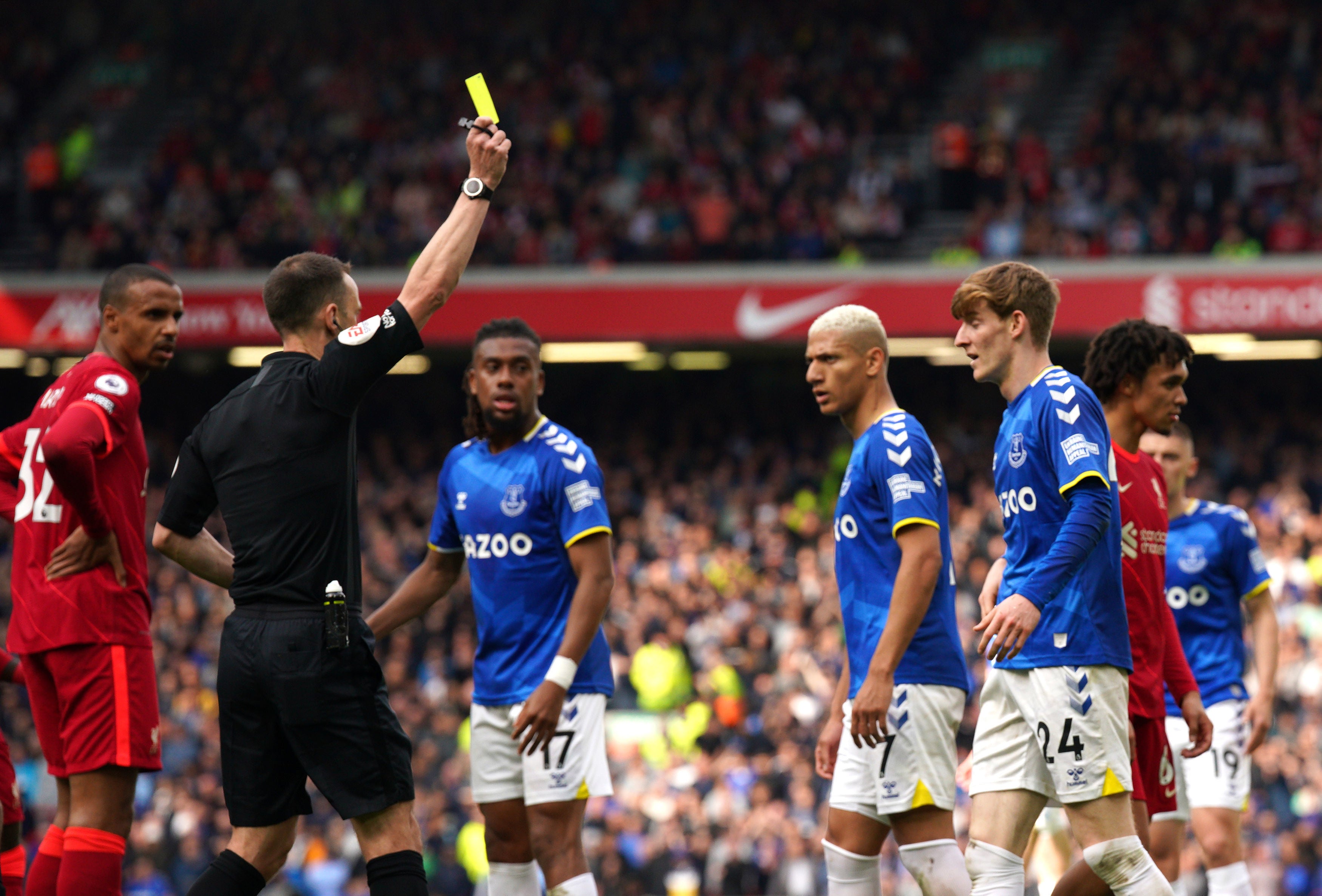 Referee Stuart Attwell shows a yellow card to Everton's Anthony Gordon