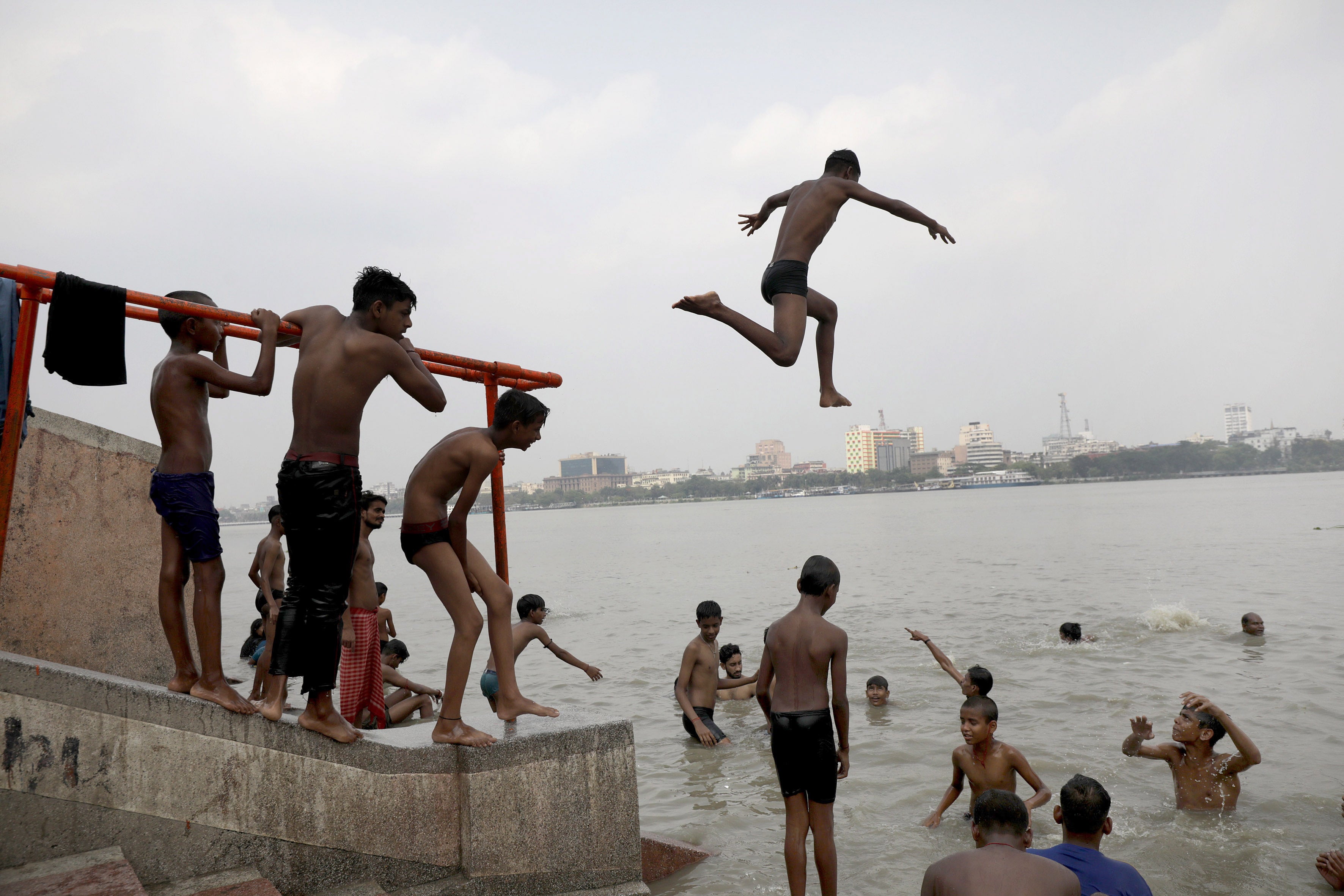 A boy dives into the Ganges River during a hot day in Kolkata, India.