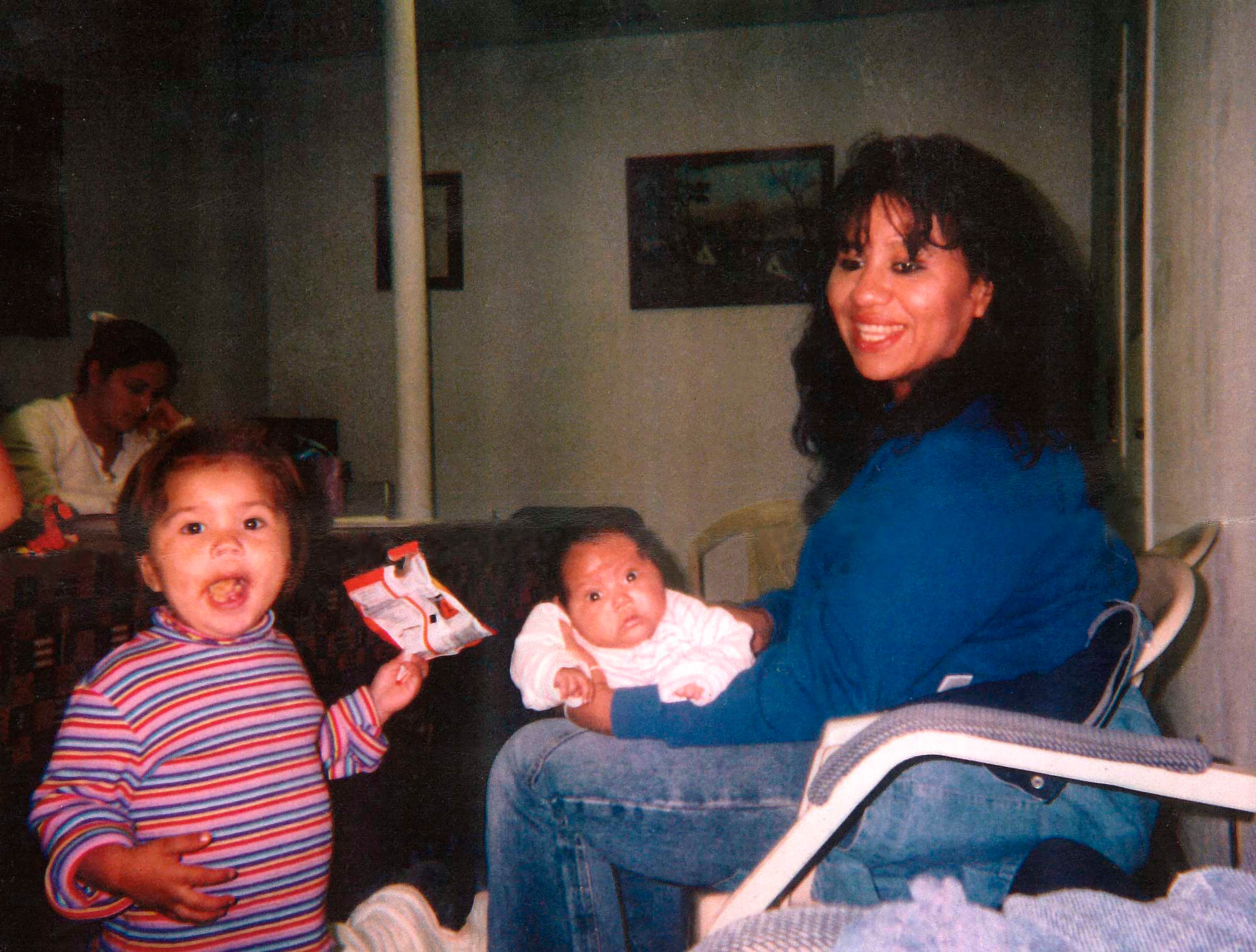 Melissa Lucio holding her daughter Mariah while her daughter Adriana stands close by