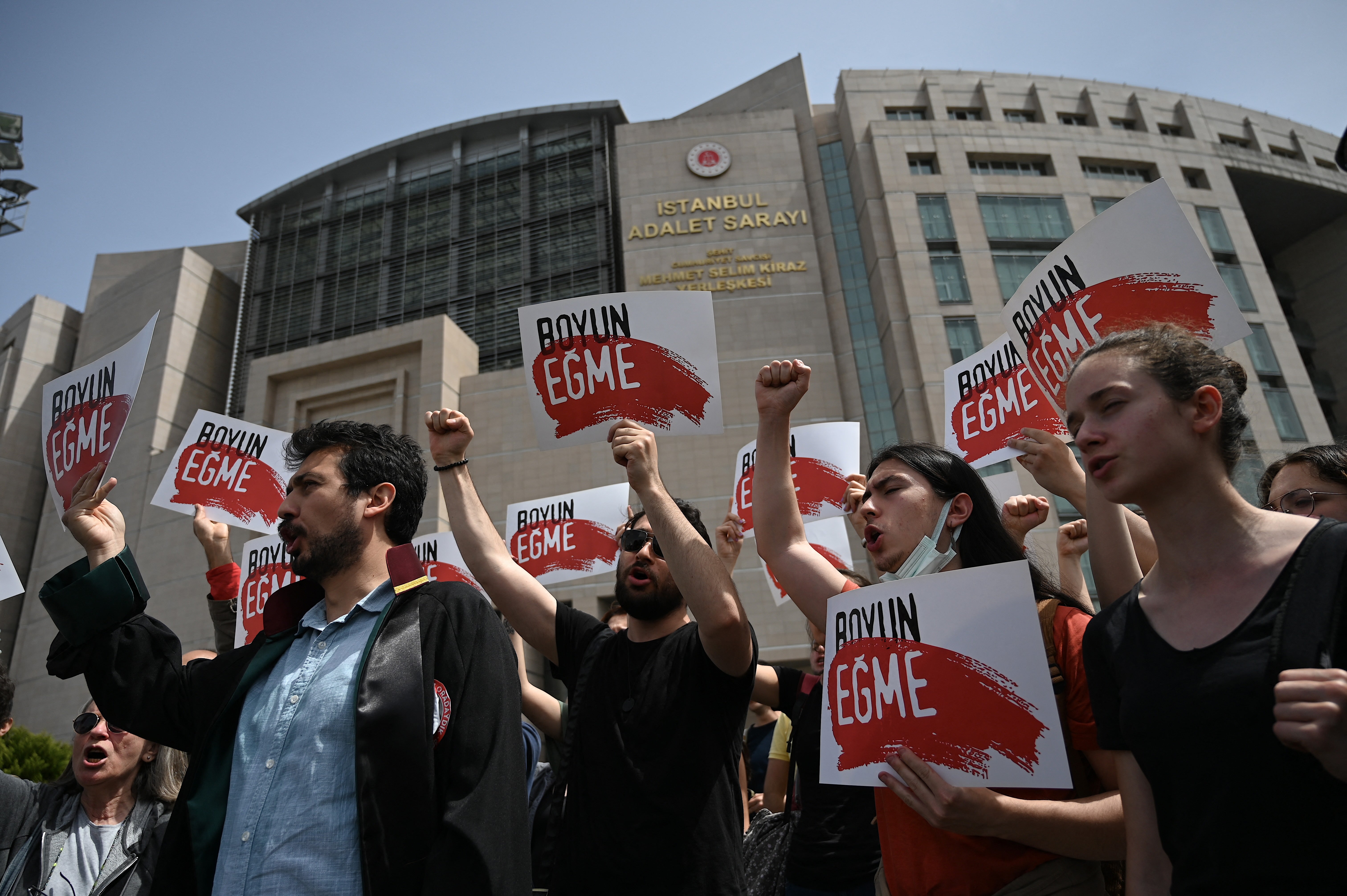 Demonstrators hold placards reading in Turkish ’do not obey’ during a protest against a Turkish court decision to sentence Kavala to life in prison