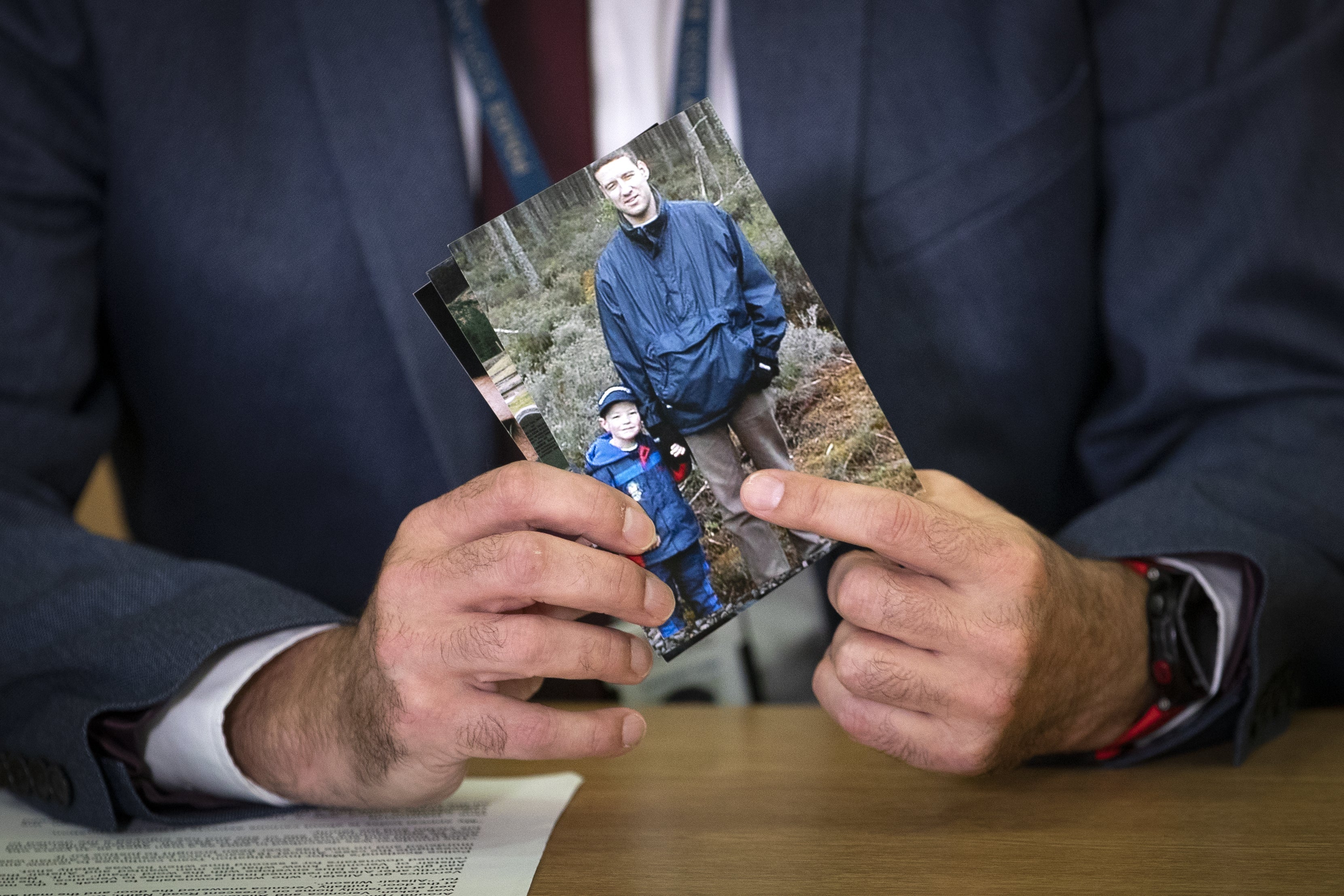 Detective Inspector Gary Winter holds a photograph dated November 28, 2004, that shows Alistair Wilson and his young son Andrew, during a press conference at Inverness Police Headquarters