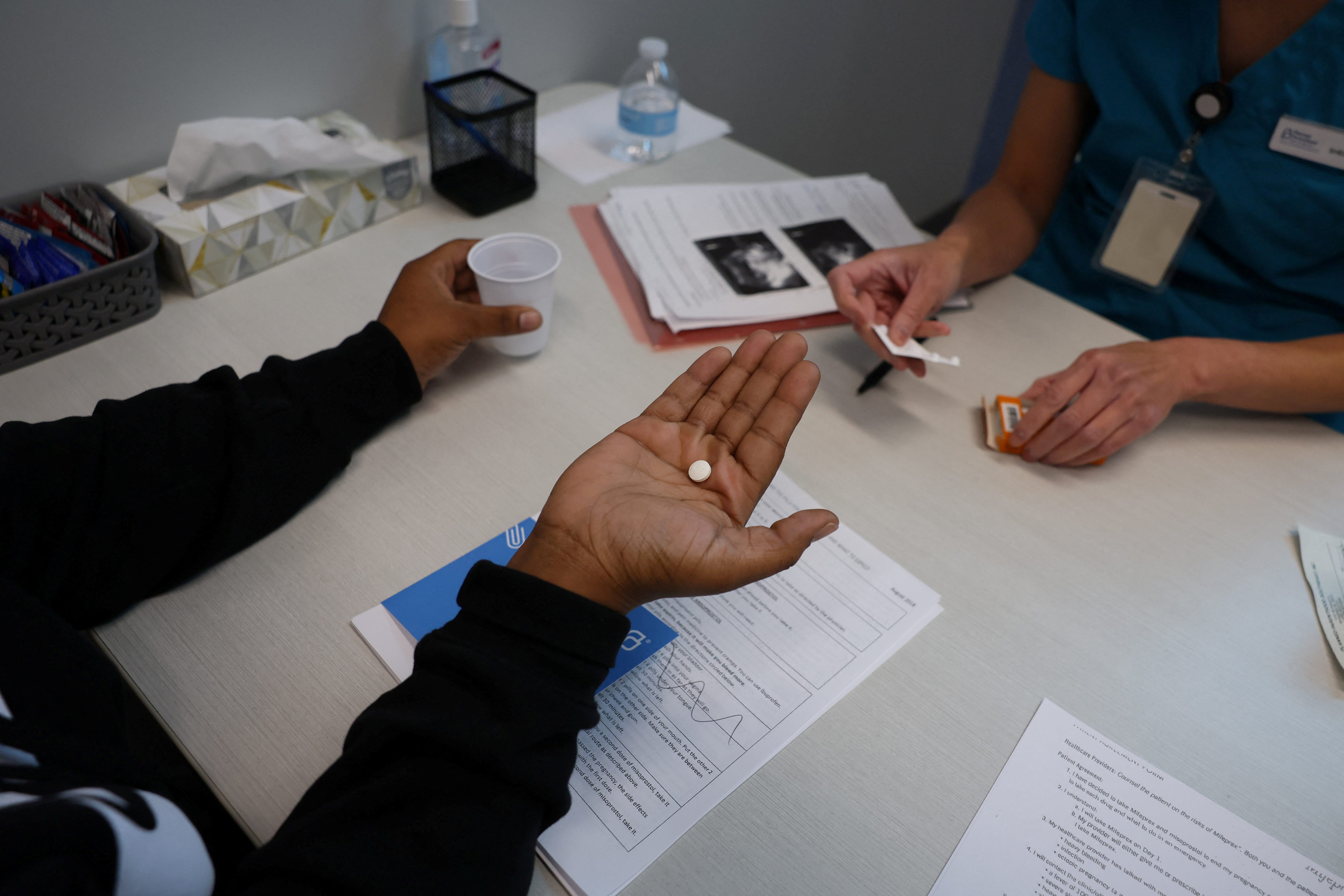 Tien gives a patient medication to start a medical abortion