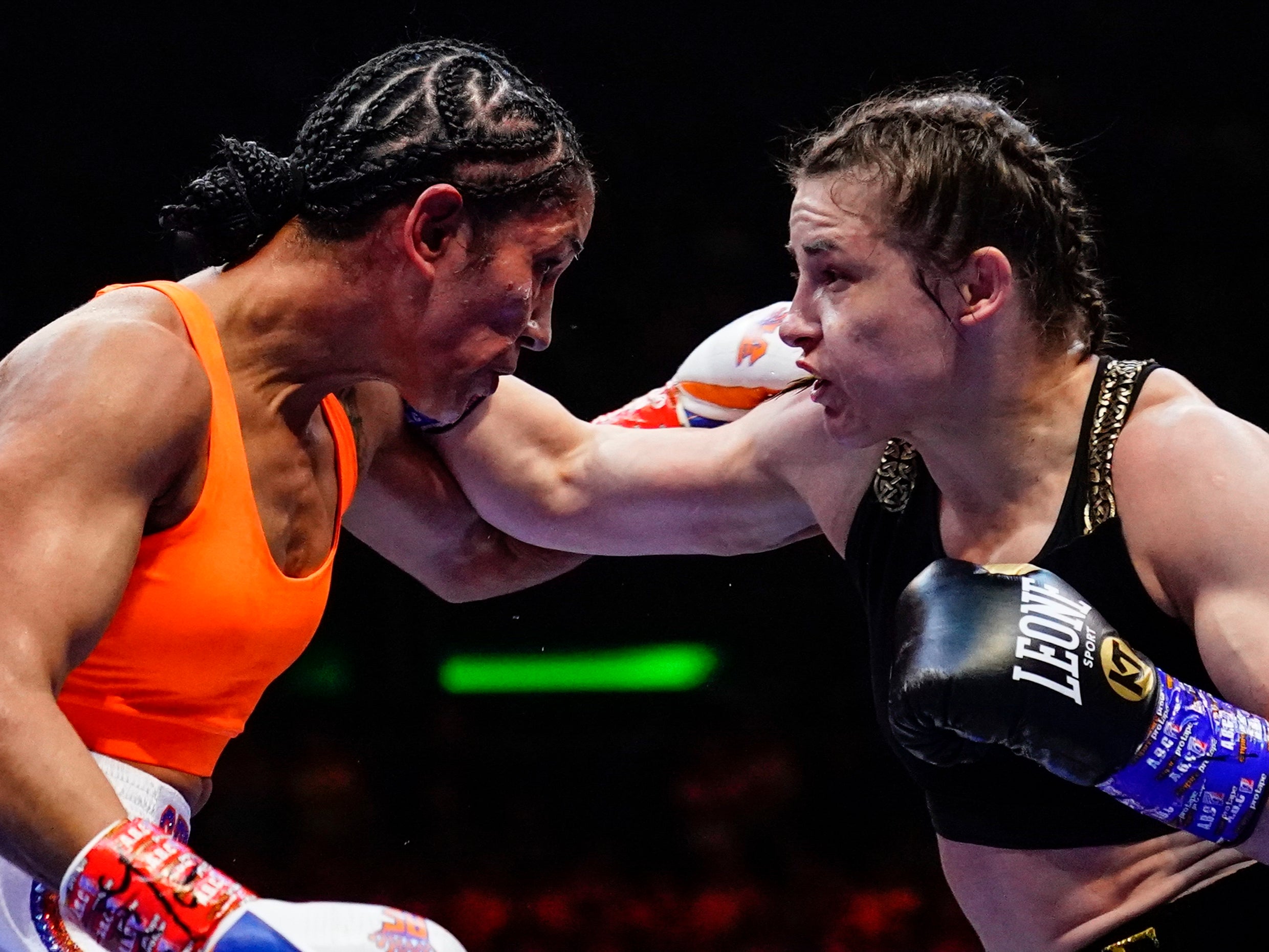 Katie Taylor (right) remained unbeaten and retained her belts with the narrow win