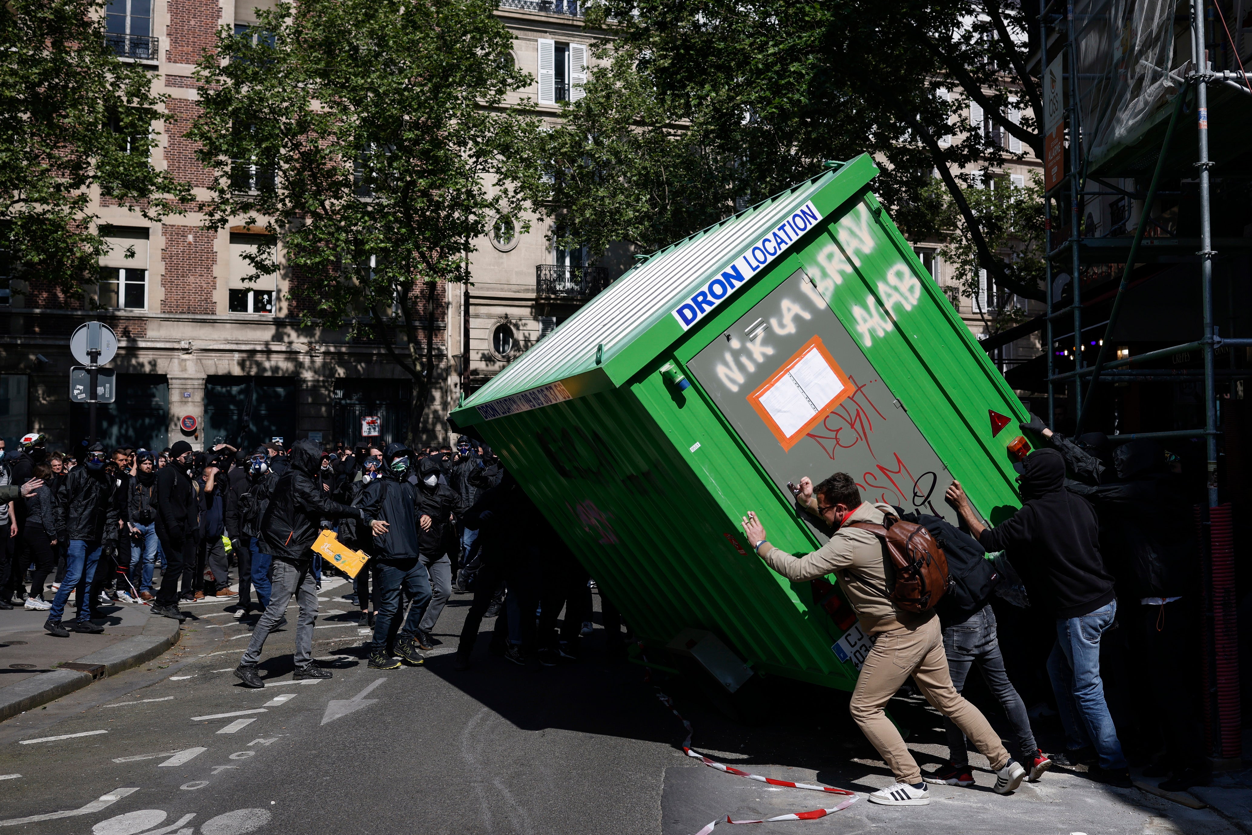 Demonstrators try to topple a cabin as they clash with the police in Paris