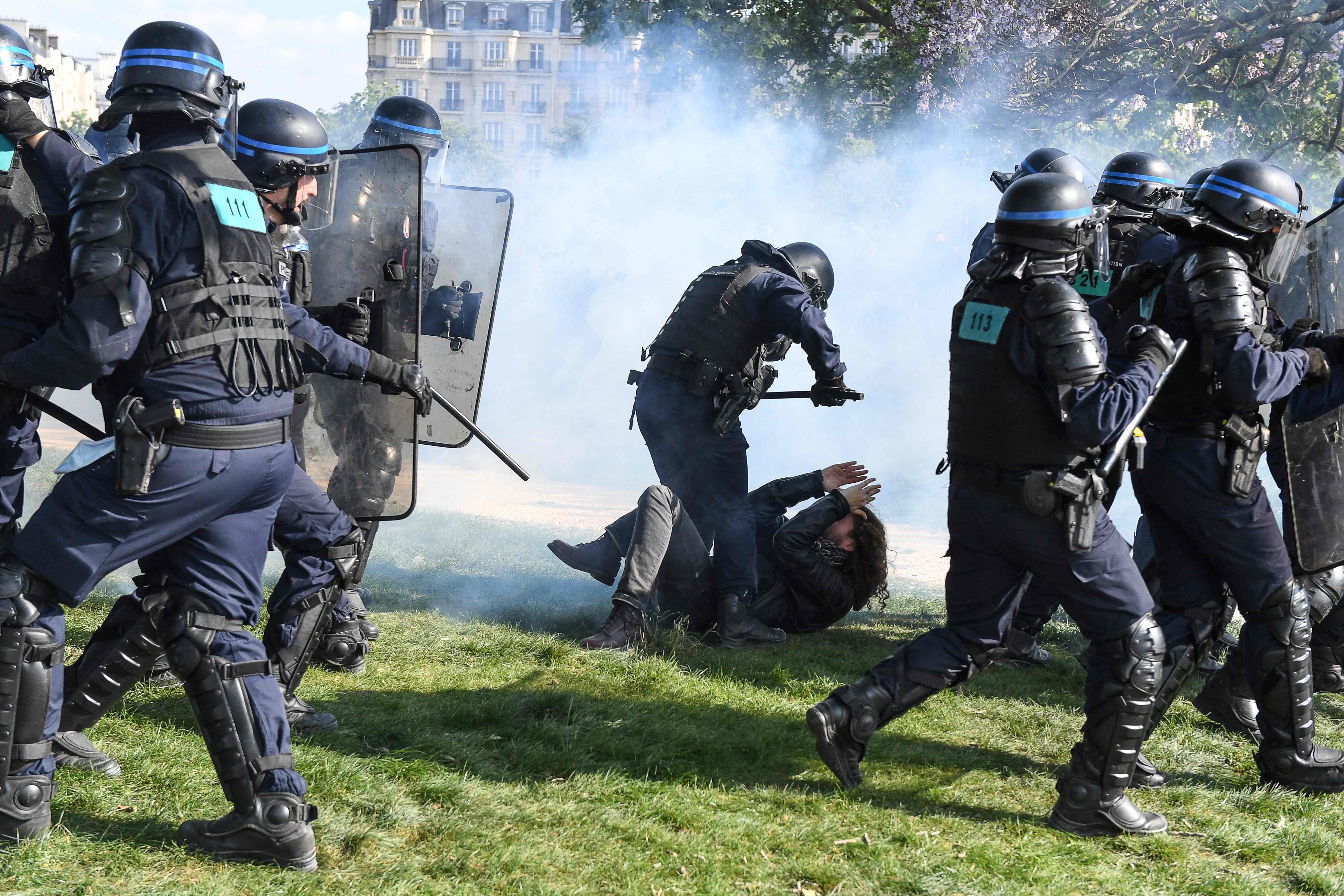 A protester reacts on the ground as a police officers clash with demonstrators