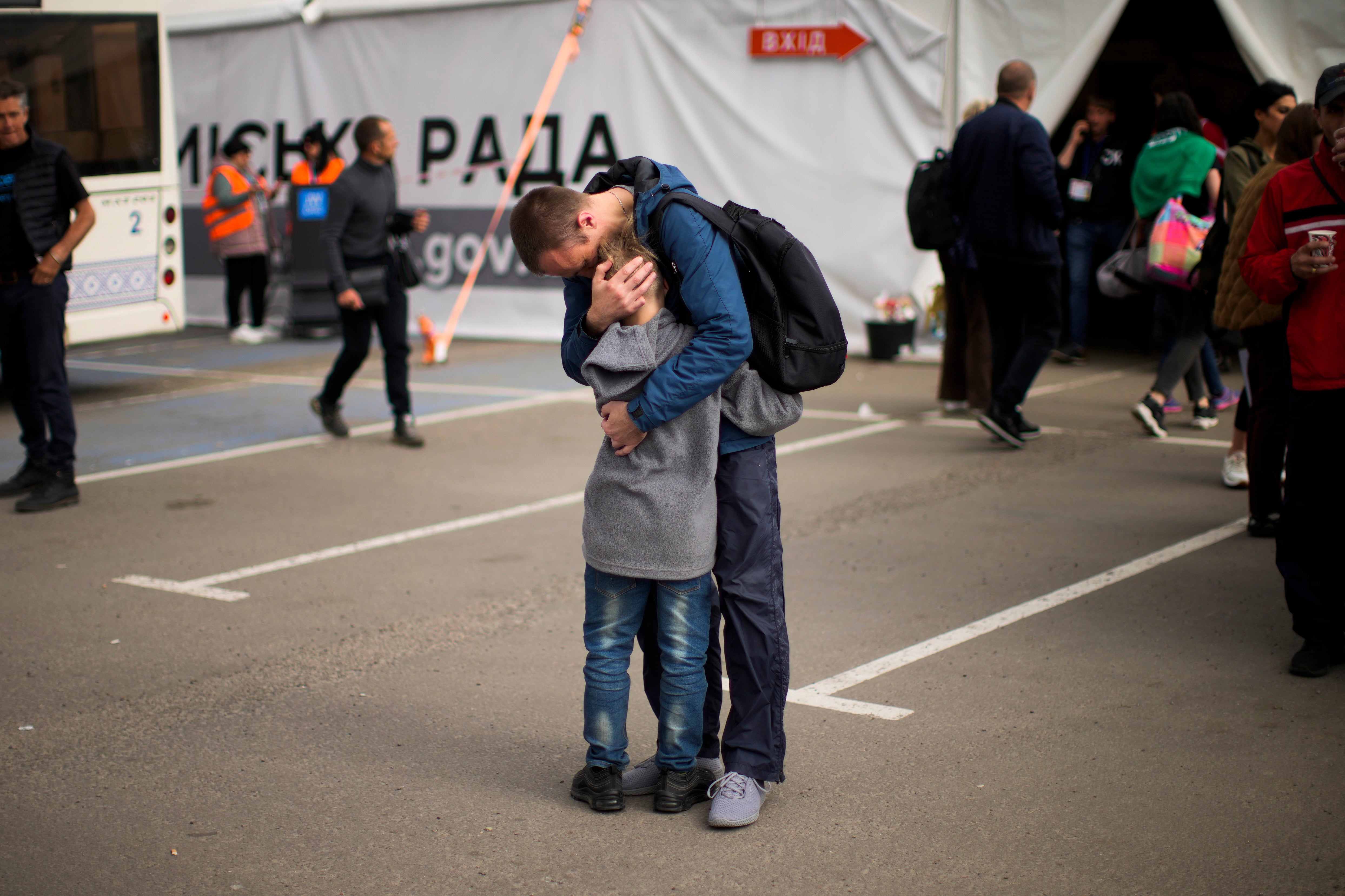 Andrii Fedorov hugs his son Makar as they are reunited at the reception centre in Zaporizhzhia
