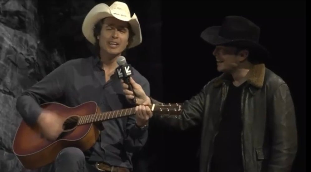 Kimbal Musk plays the guitar and sings along with his brother Elon, holding the microphone, at SXSW in 2018