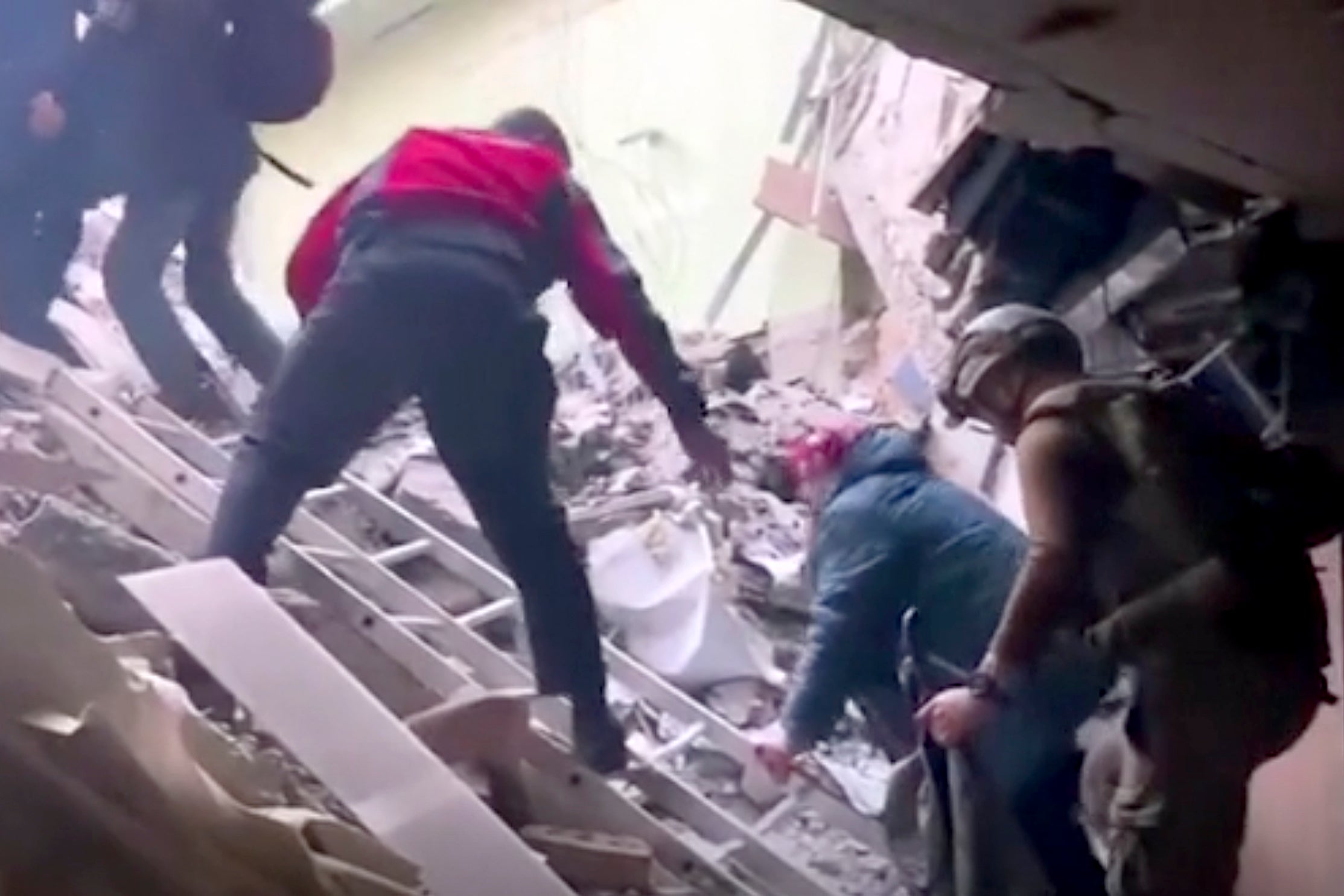 This frame taken from an undated video provided Sunday, May 1, 2022 by the Azov Special Forces Regiment of the Ukrainian National Guard shows people climbing over debris at the Azovstal steel plant