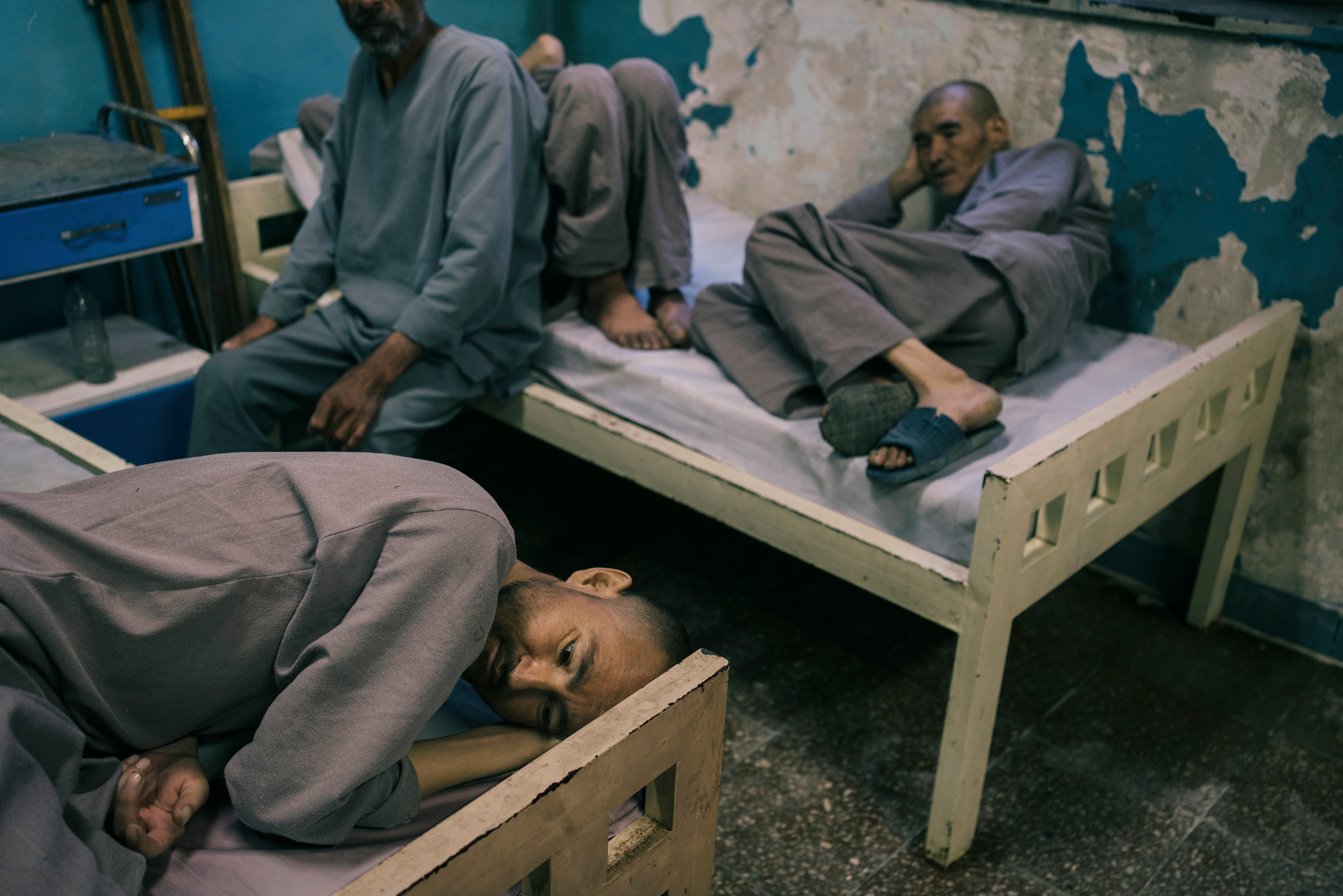 Patients of the rehabilitation centre in Kabul lay on beds in their first period of detoxification