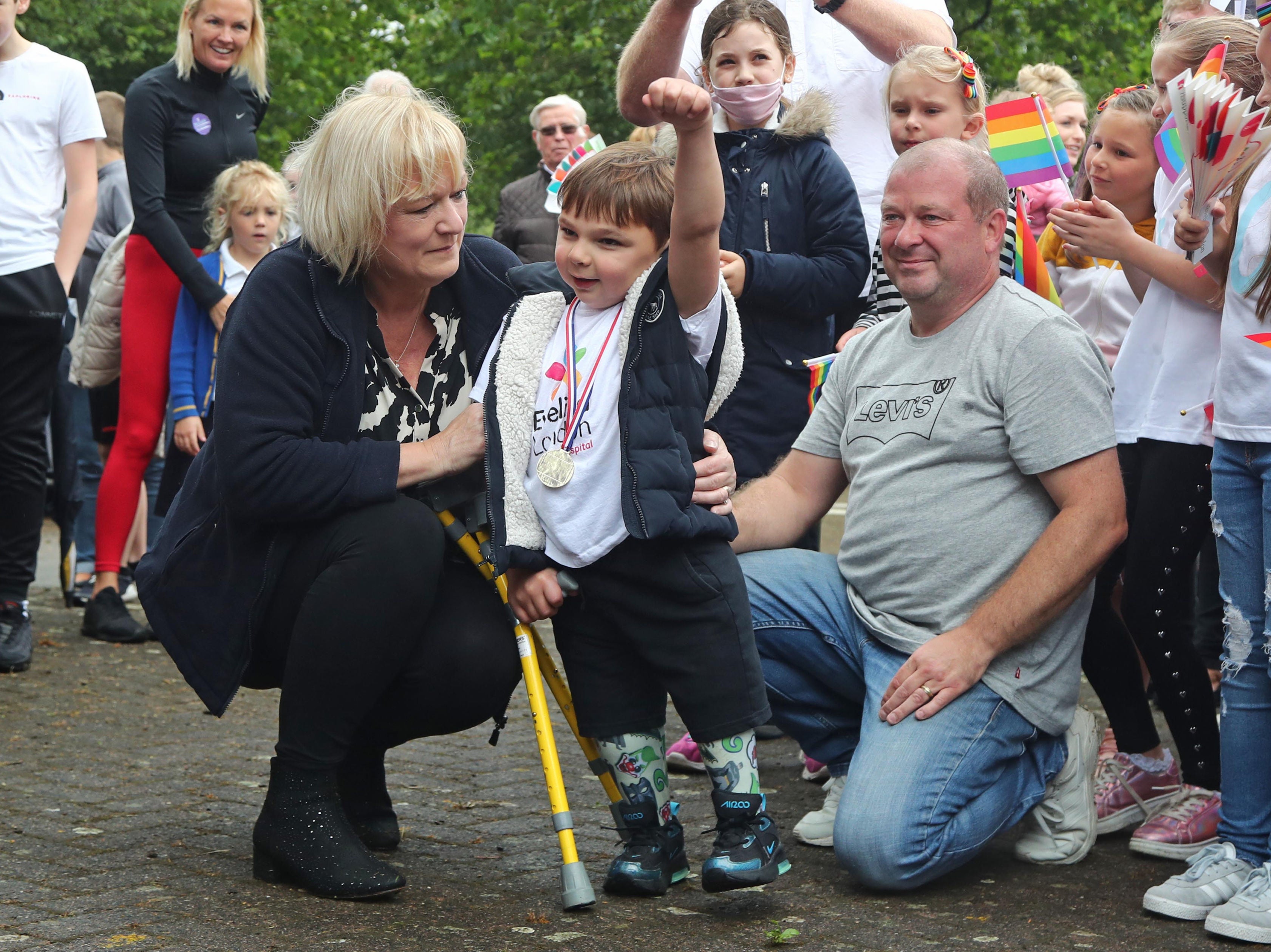 Tony Hudgell pictured with his adoptive parents Paula and Mark Hudgell after finishing a fundraising walk in June 2020