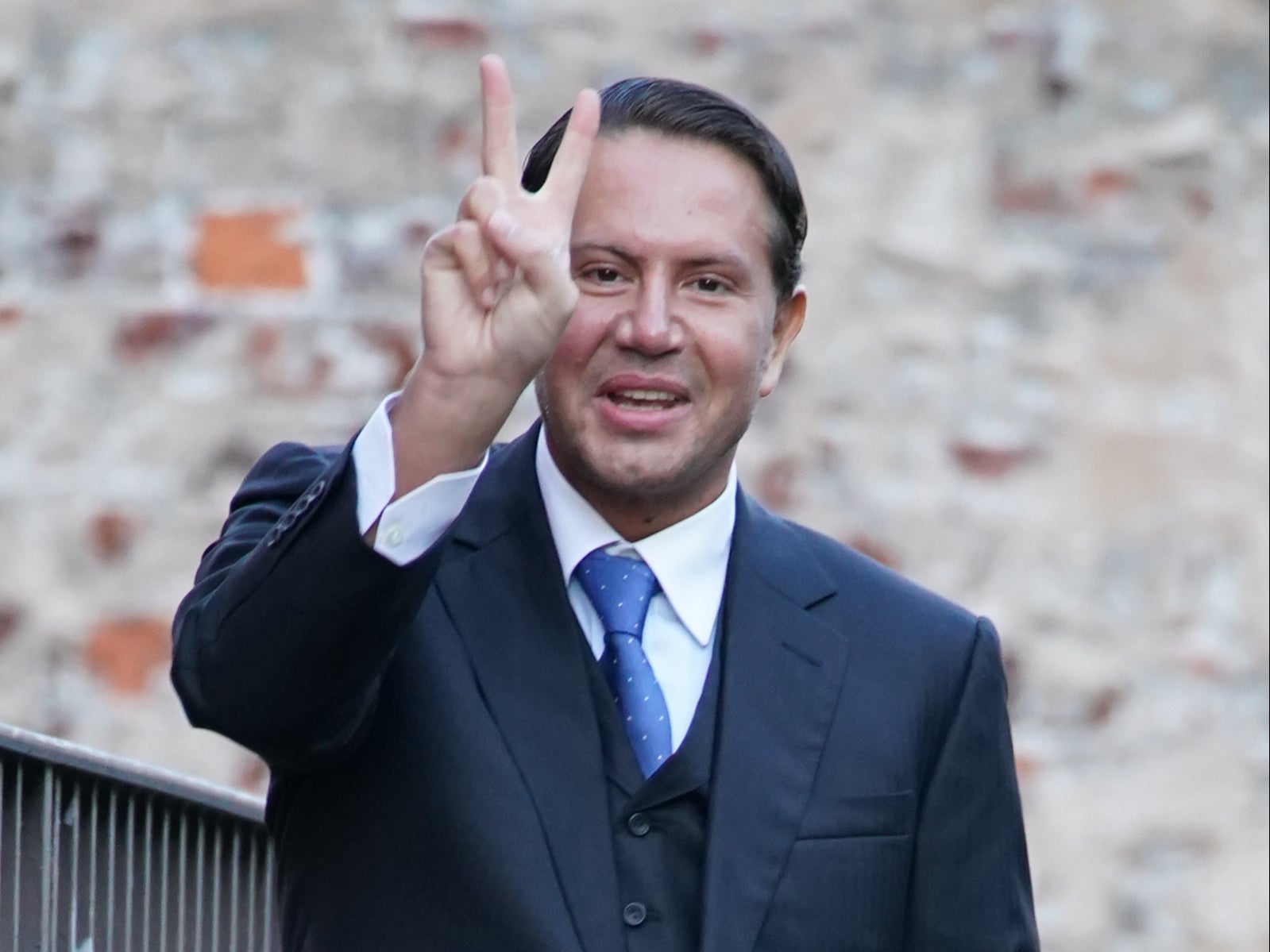 Socialite James Stunt makes a hand gesture as he arrives at an earlier Leeds Crown Court hearing on money-laundering charges