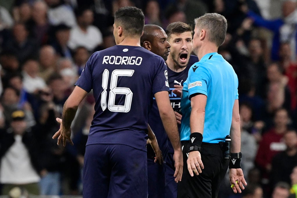 City players surround referee Orsato after he awarded Real’s tie-winning penalty