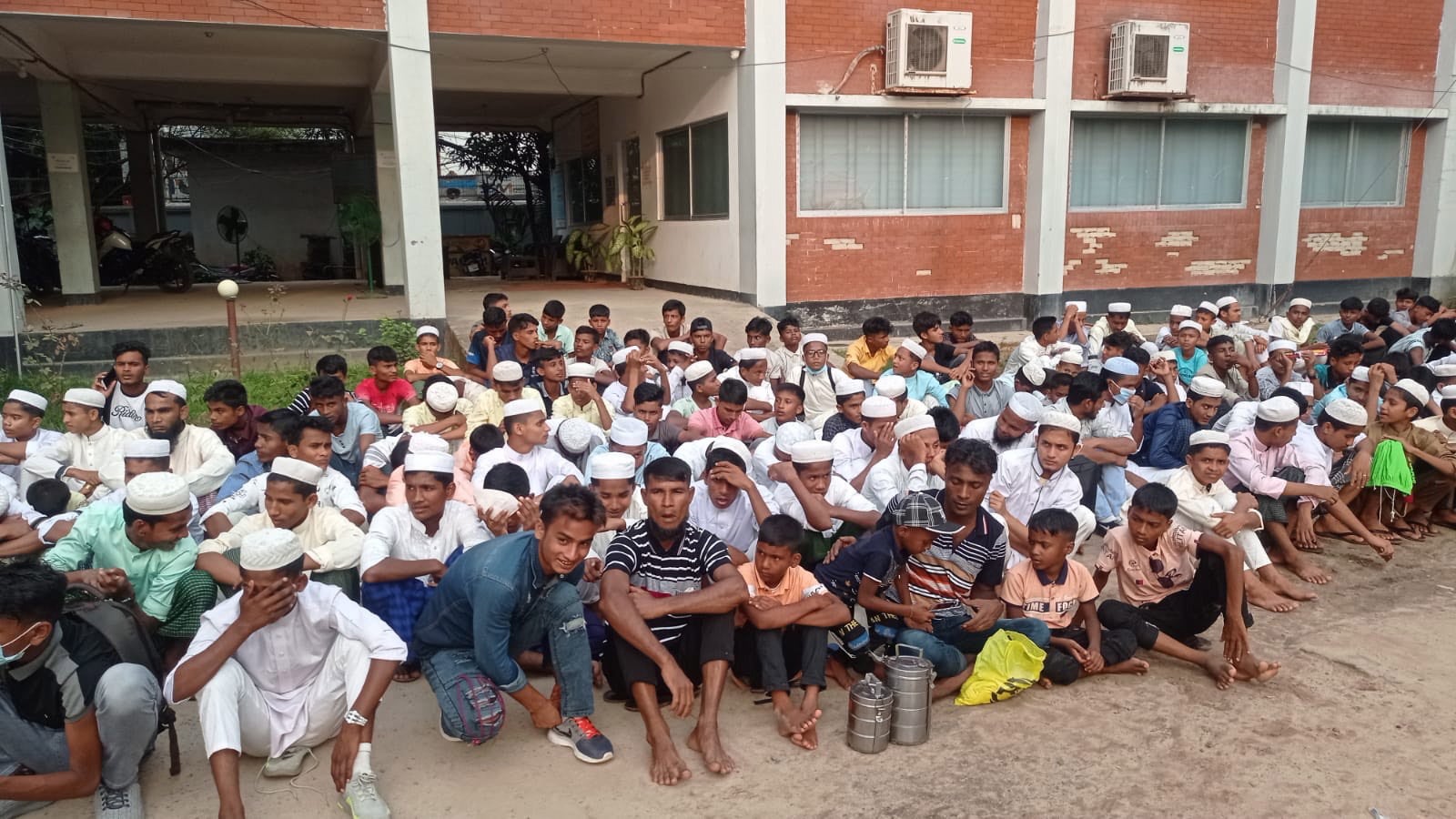 A group of Rohingya refugees, detained while on a visit to a beach, sit in front of a police station in Cox’s Bazar, Bangladesh on 4 May 2022