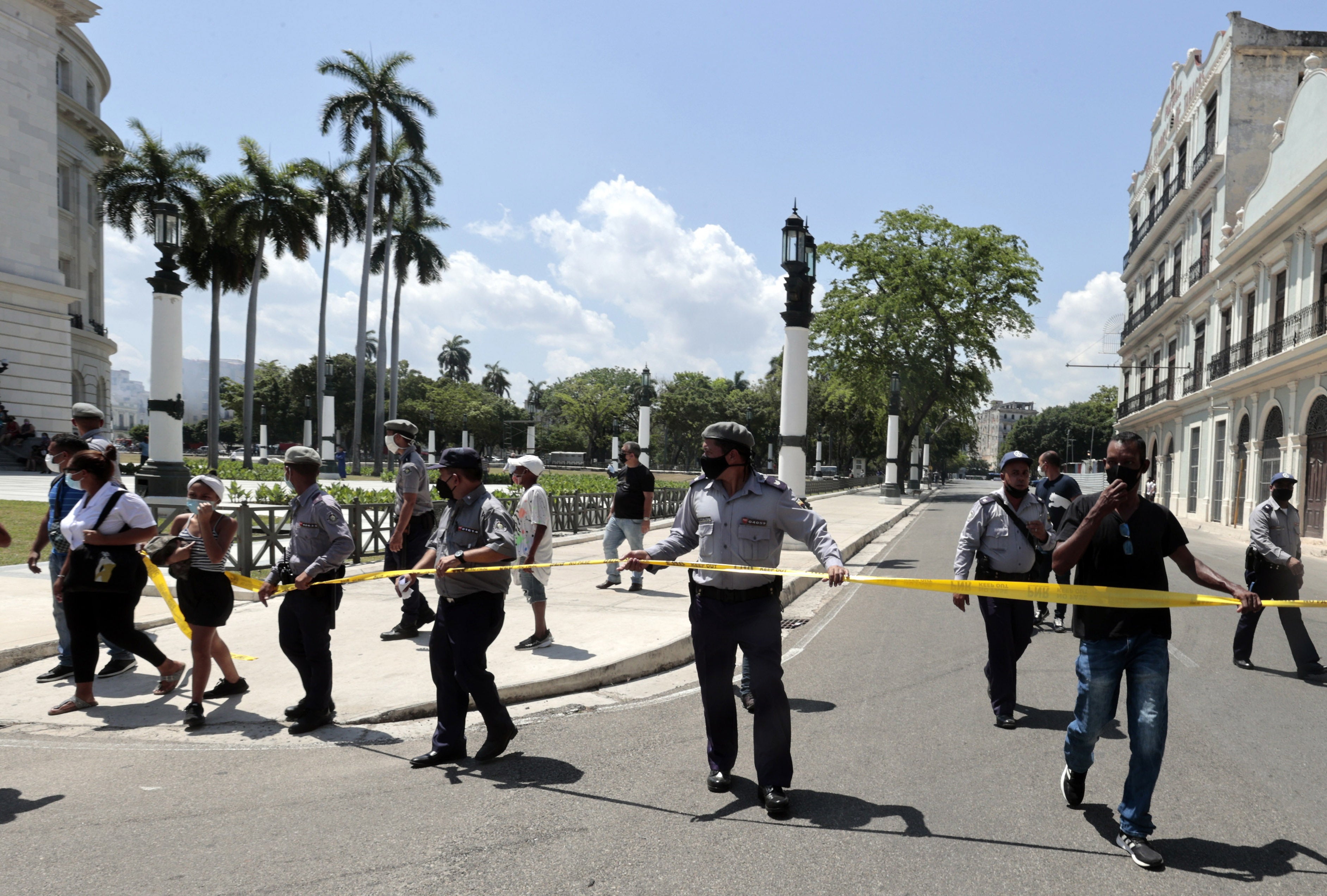 Members of the police move people away from the area where an explosion was registered at the Hotel Saratoga, in Havana, Cuba, 6 May 2022