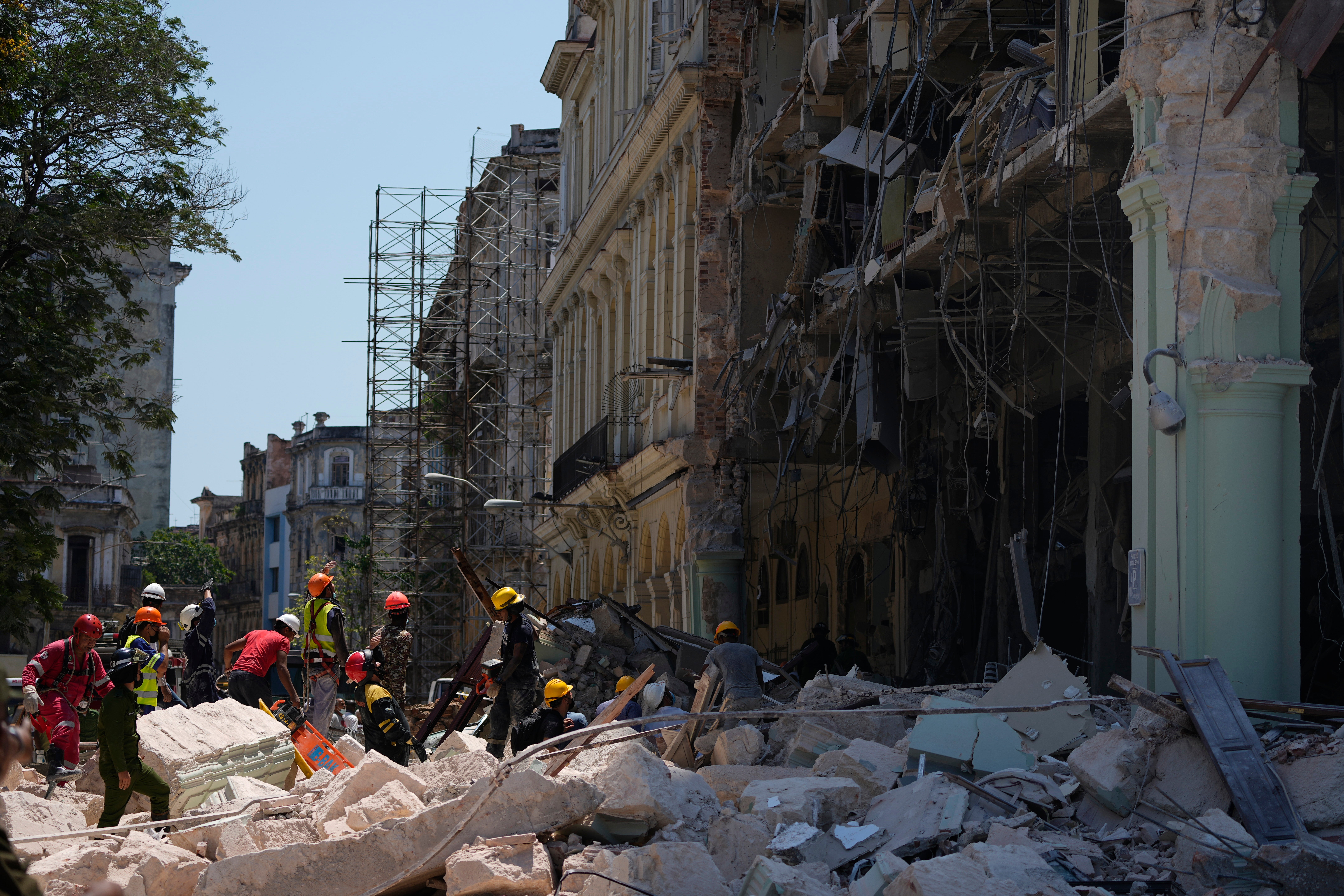 Emergency workers walk amid the rubble outside the five-star Hotel Saratoga after a deadly explosion in Old Havana, Cuba, Friday, May 6, 2022