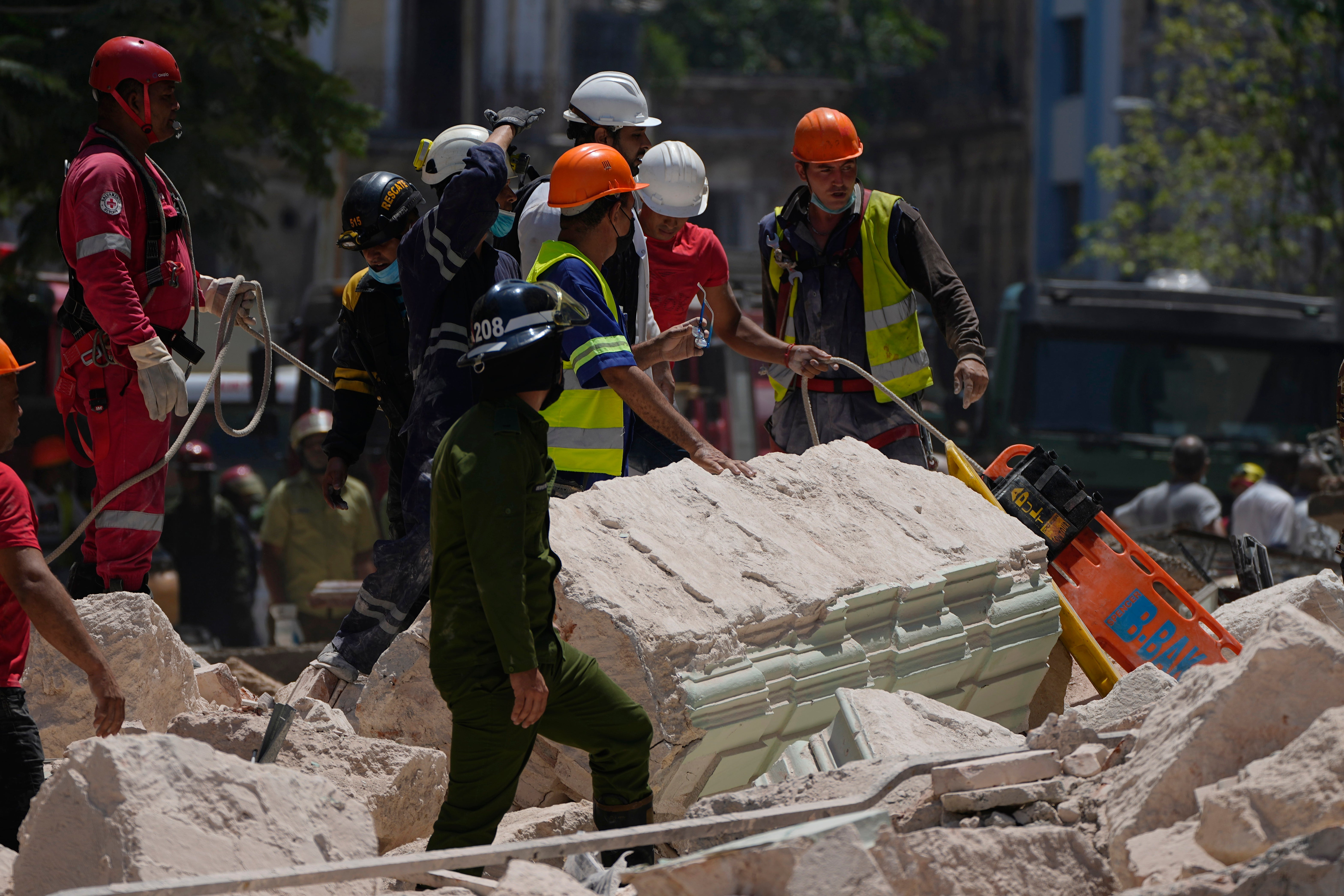 Emergency workers with a stretcher stand amid the rubble outside the five-star Hotel Saratoga after a deadly explosion in Old Havana, Cuba, Friday, May 6, 2022