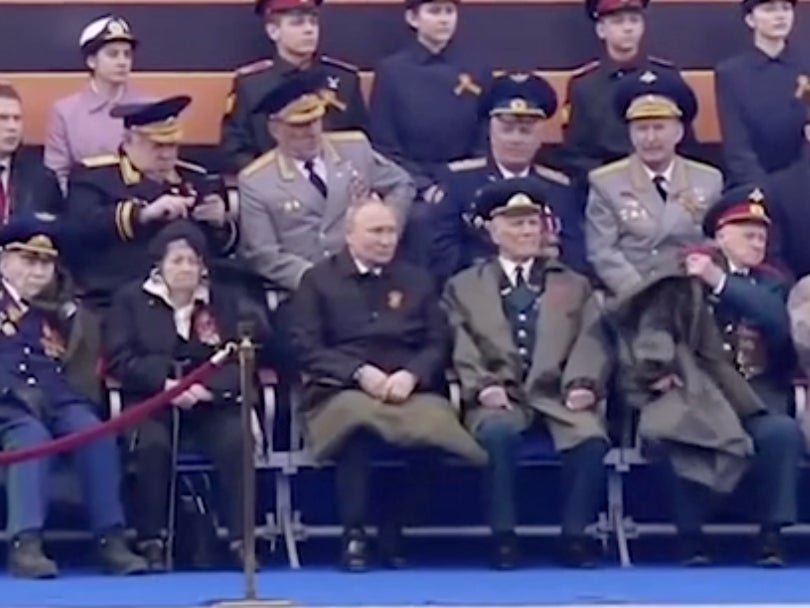 Putin is the only person present who is using a blanket for warmth