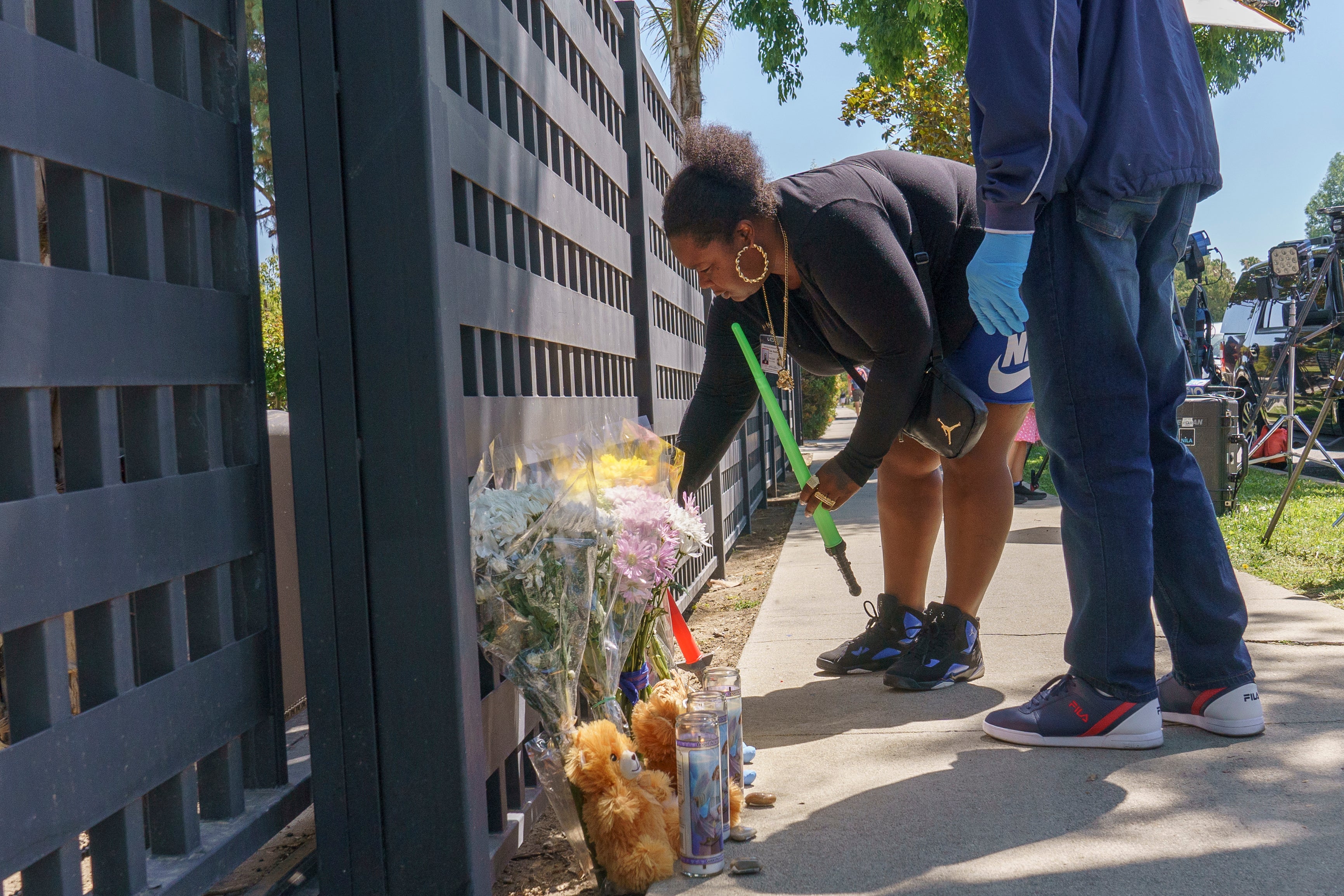 Los Angeles County worker Tiana Baudin leaves several toys outside a ranch-style house in the West Hills neighborhood of the San Fernando Valley, in Los Angeles, Monday, May 9, 2022.