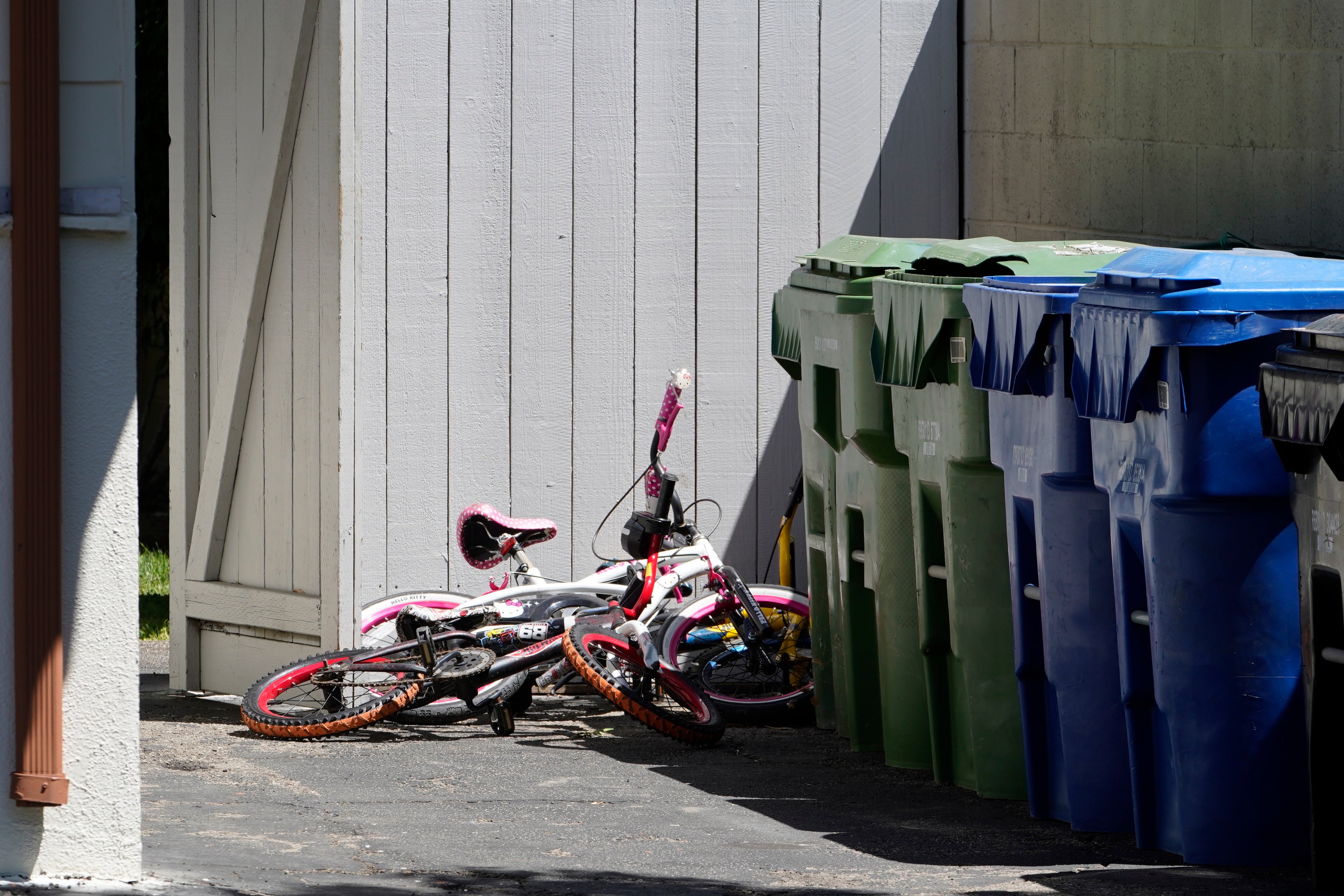 Childrens' bycicles are left near trash cans of the Flores home in Los Angeles, Monday, May 9, 2022.