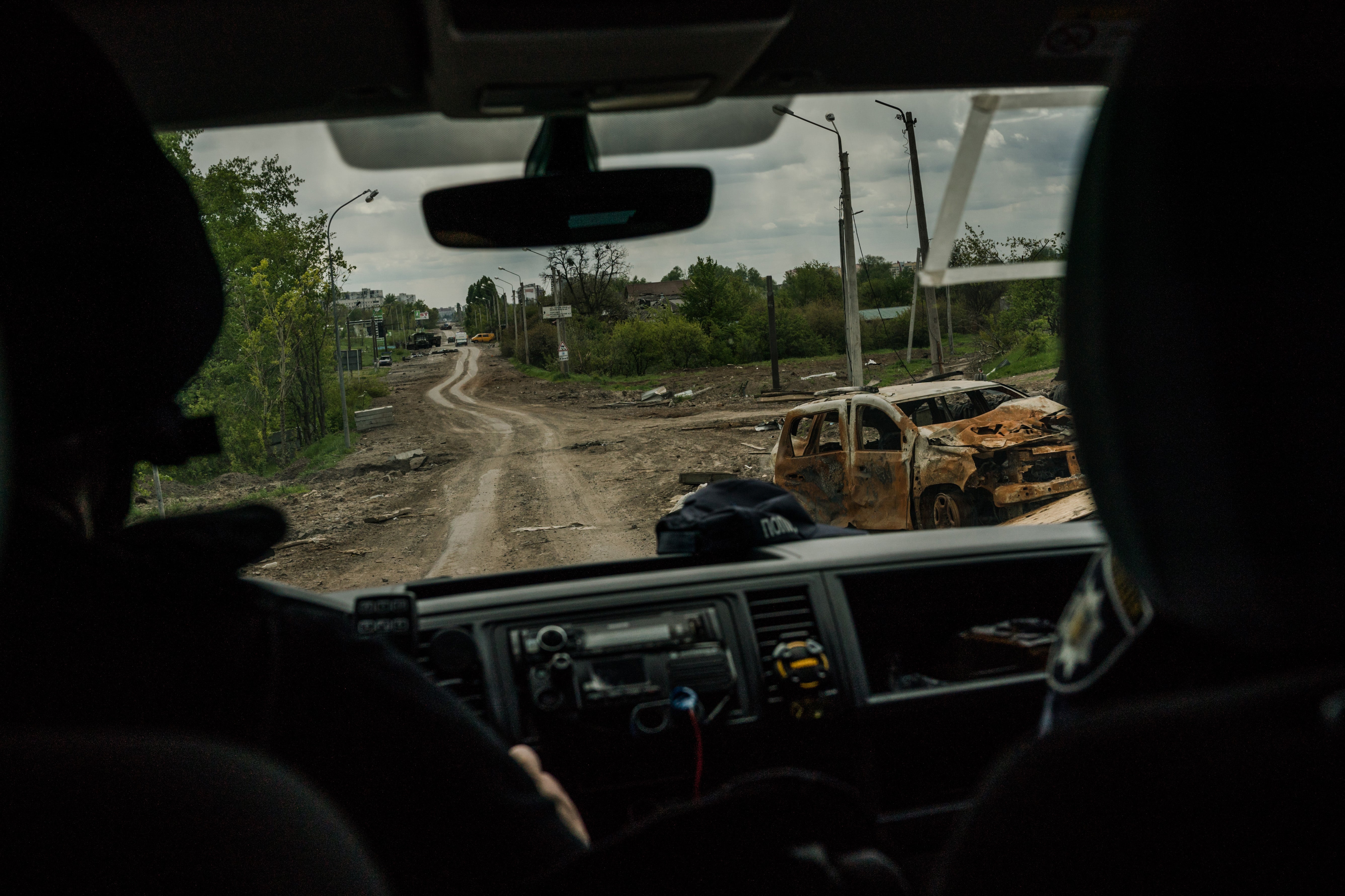 Members of the Kharkiv police forensic unit make their way to a crime scene near Tsyrkuny