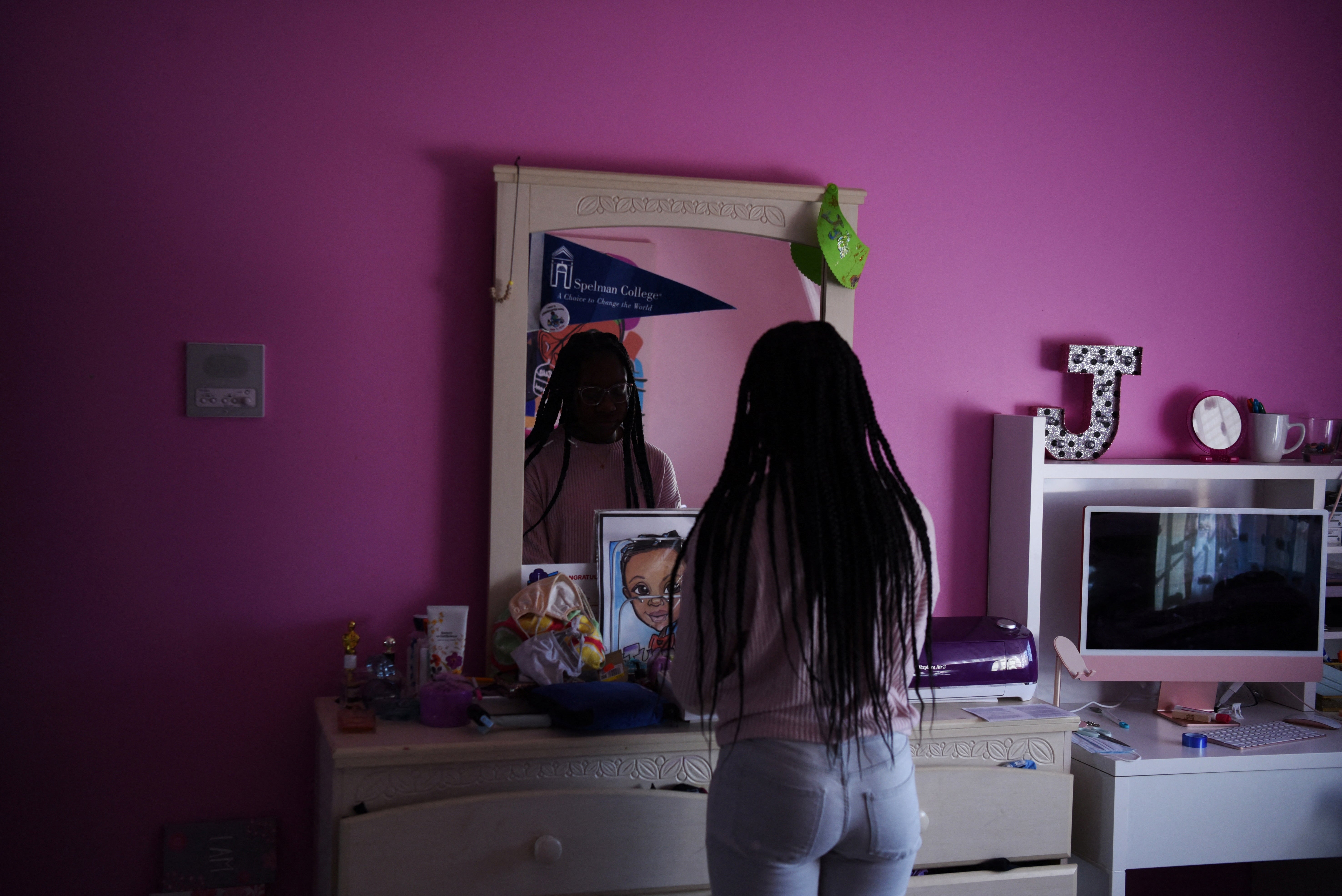 Justise McGowan looks in a mirror while posing for a portrait, on her father’s birthday