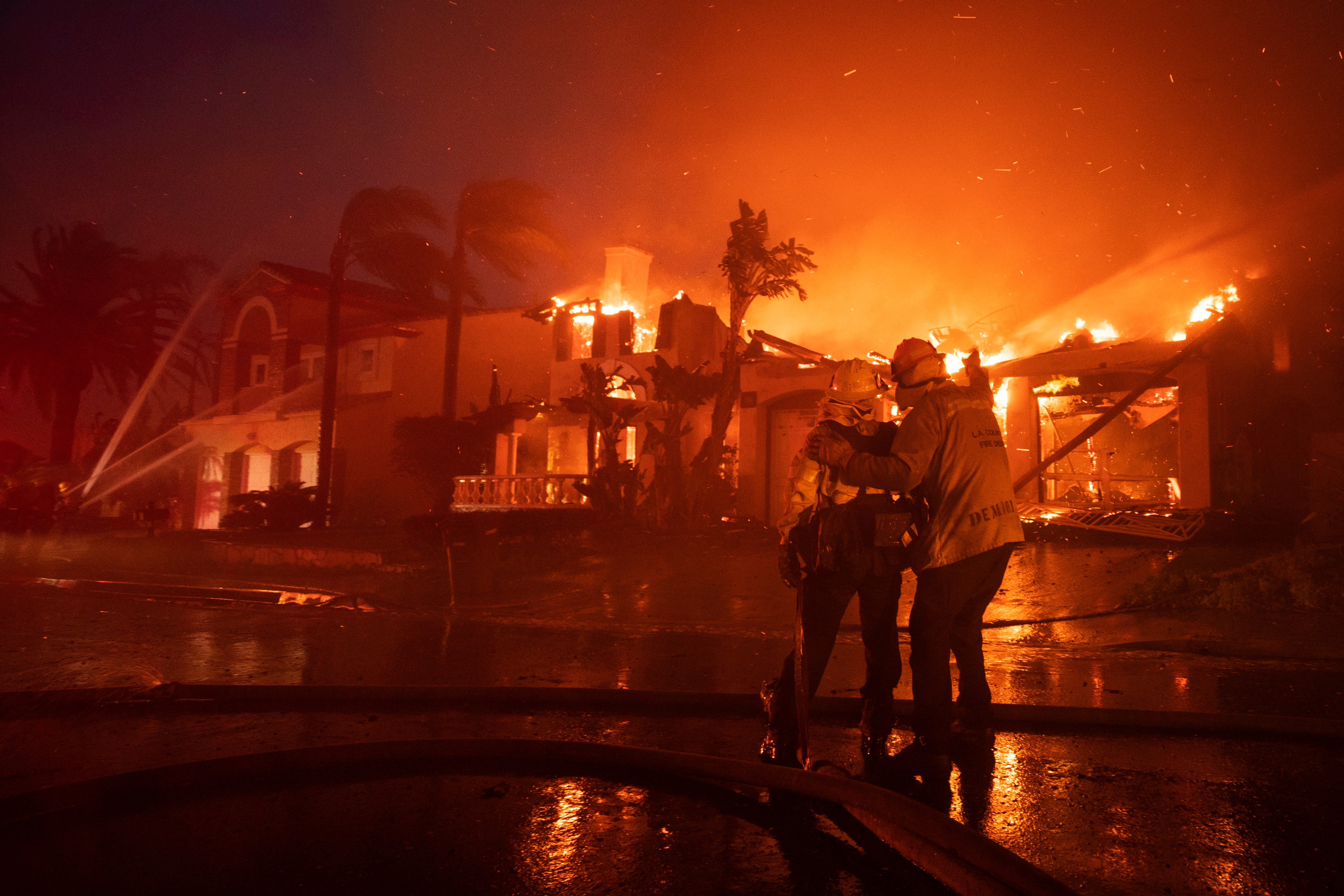 Firefighters battle home blazes last night in Laguna Niguel. Over 20 homes have been destroyed by a fire that started in the nearby canyon