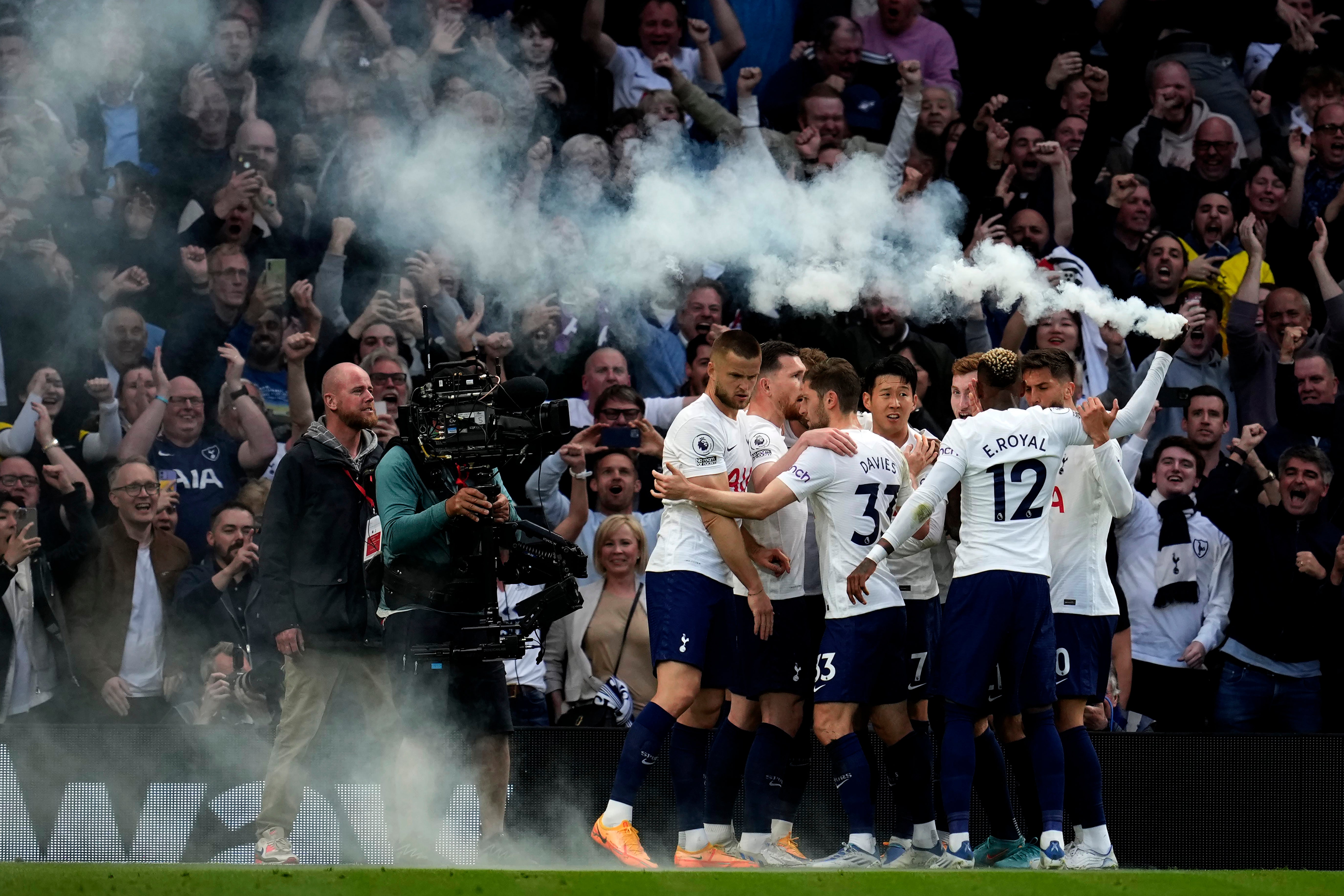 Tottenham’s Emerson Royal holds up a flare as he celebrates with his teammates