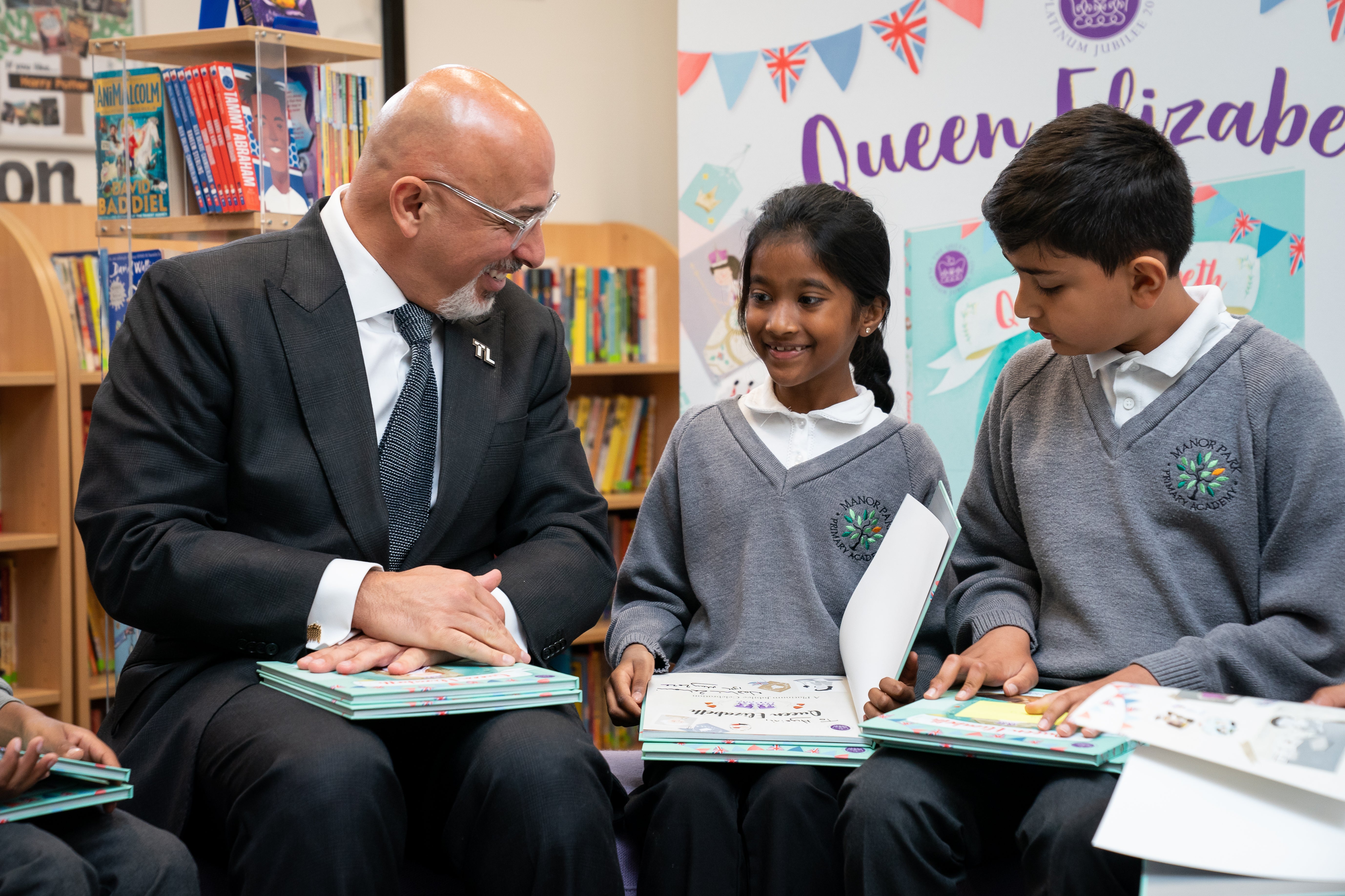 Education Secretary Nadhim Zahawi reads the commemorative Jubilee book with Year 5 pupils at Manor Park Primary School in Sutton, south London (Aaron Chown/PA)