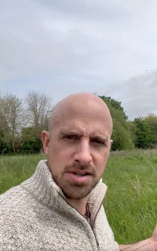 Jonathan Goodwin shares a message from a field while in his wheelchair