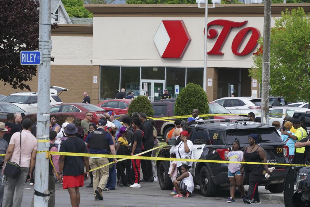 People gather outside a supermarket where several people were killed in a shooting, Saturday in Buffalo