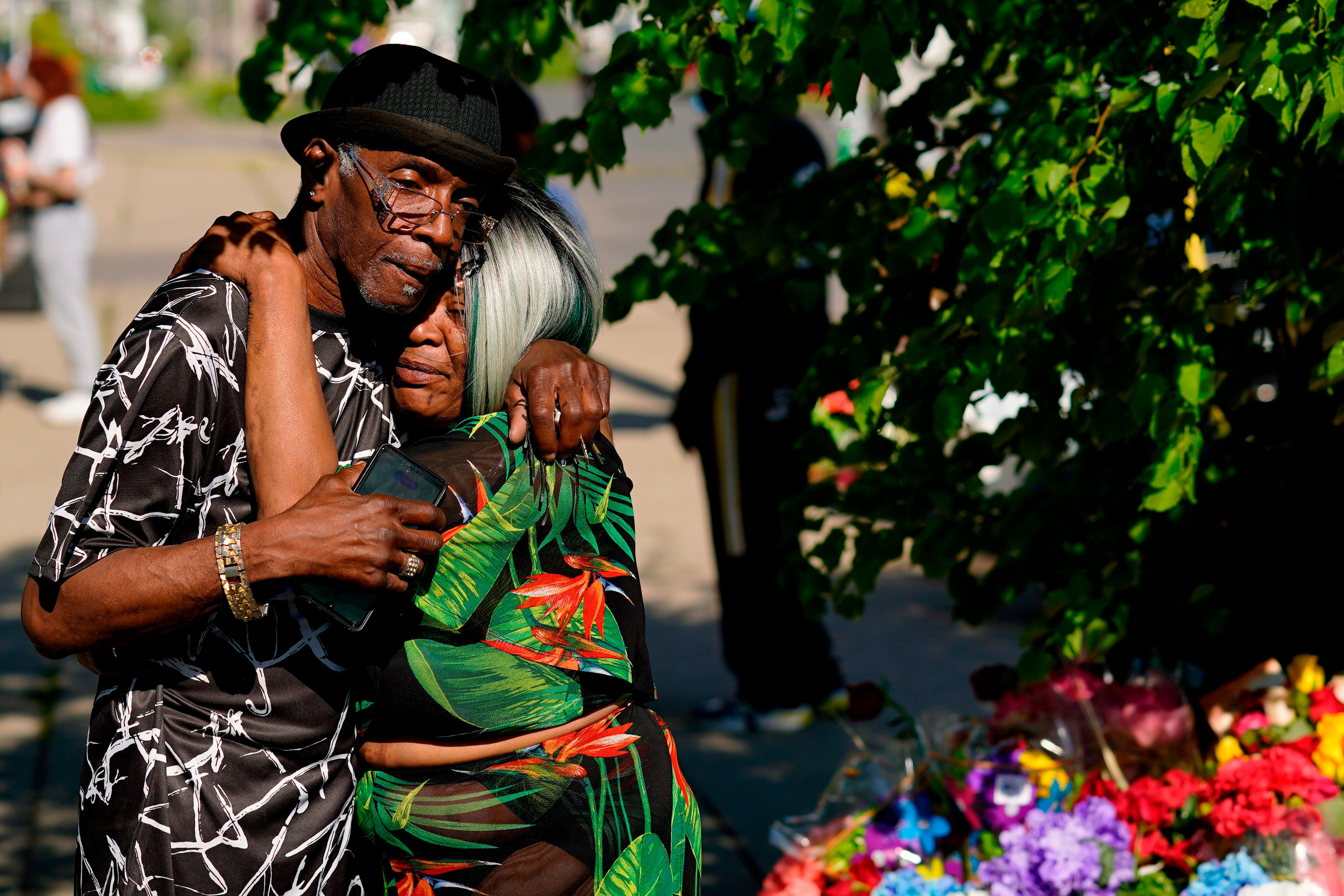 People embrace outside the scene of the Buffalo shooting