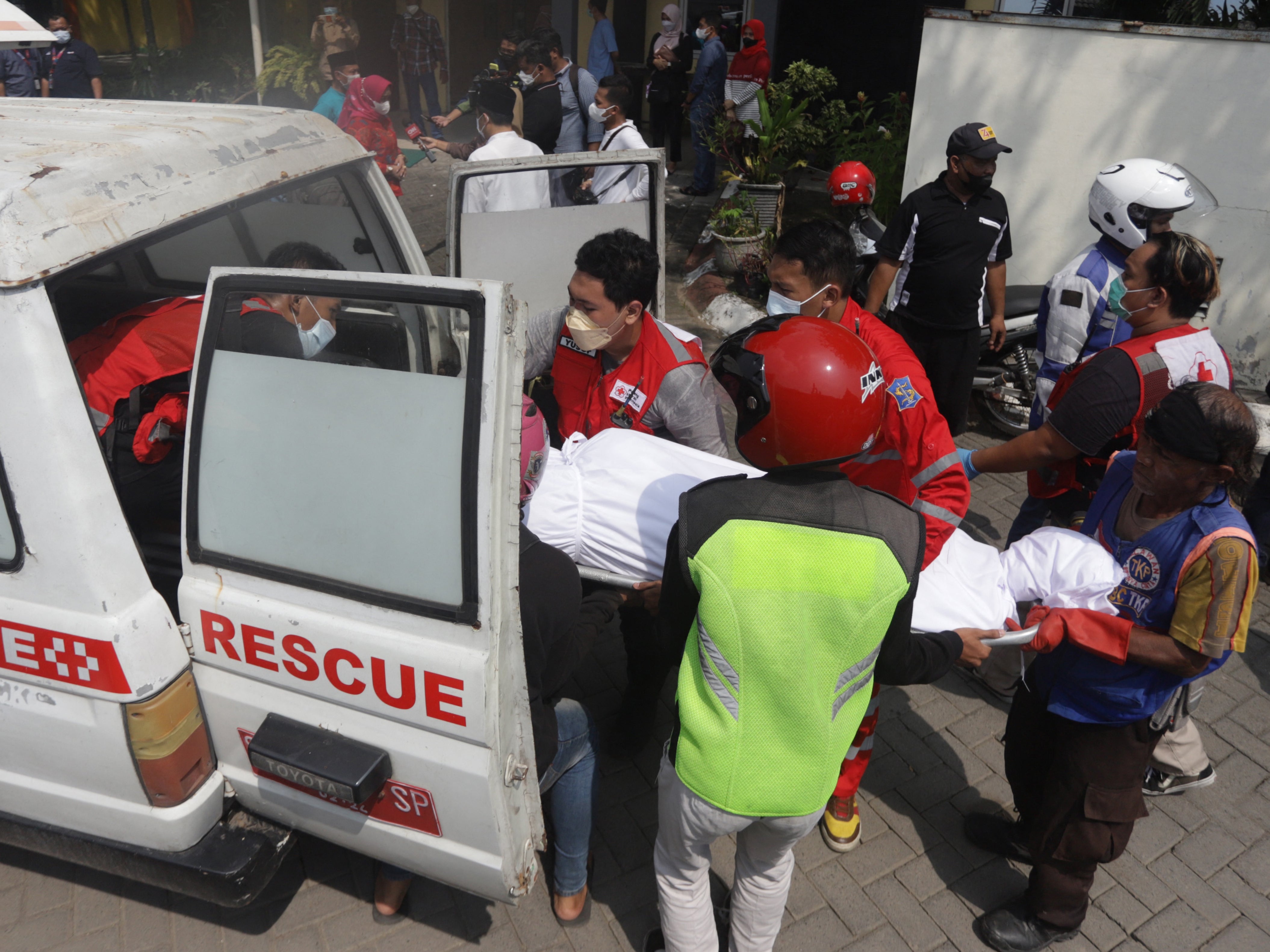 Medical workers load a victim’s body into a vehicle after a bus crash in Mojokerto on 16 May 2022