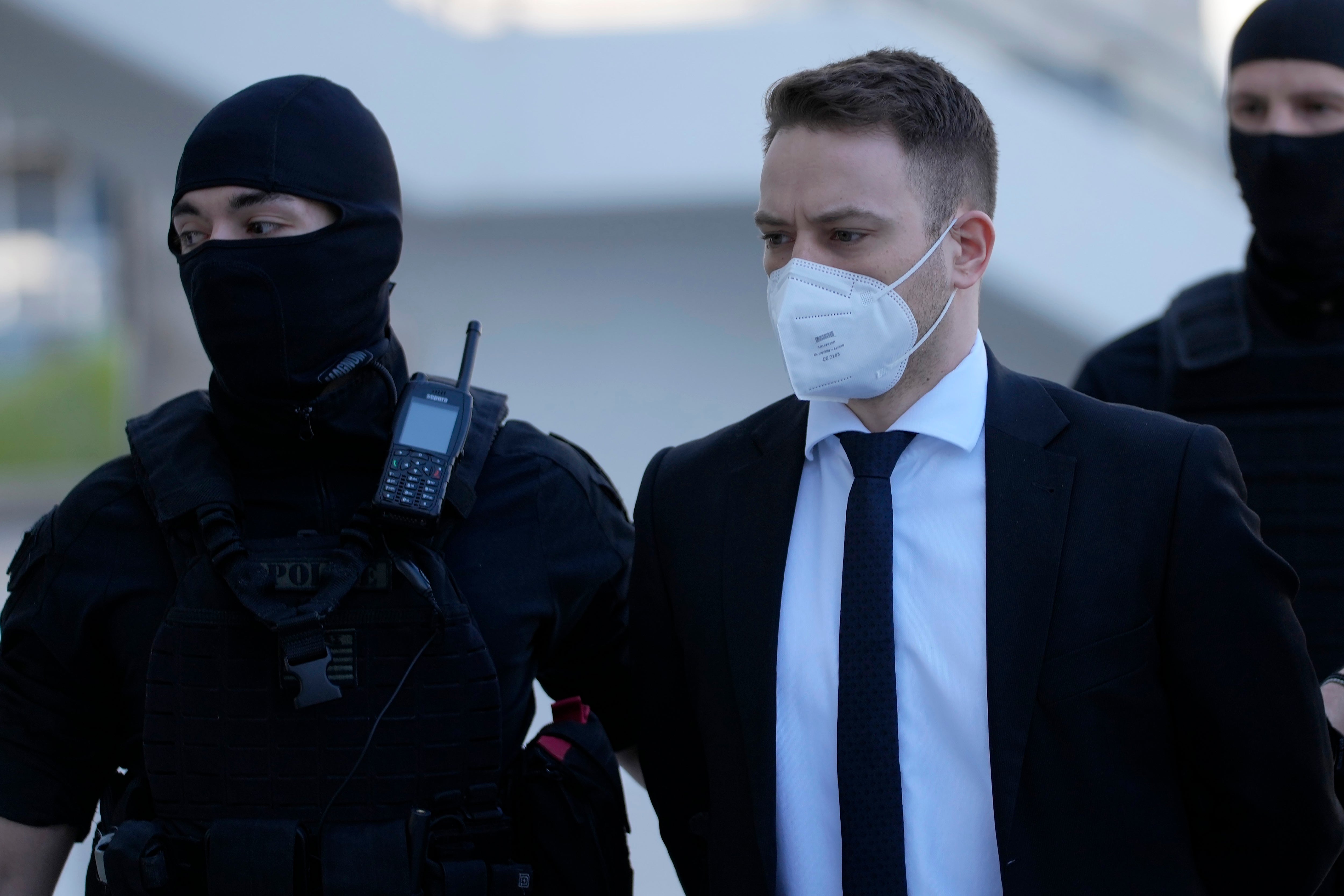 Babis Anagnostopoulos, a Greek pilot and flight instructor, right, escorted by policemen arrives at a court in Athens, Greece