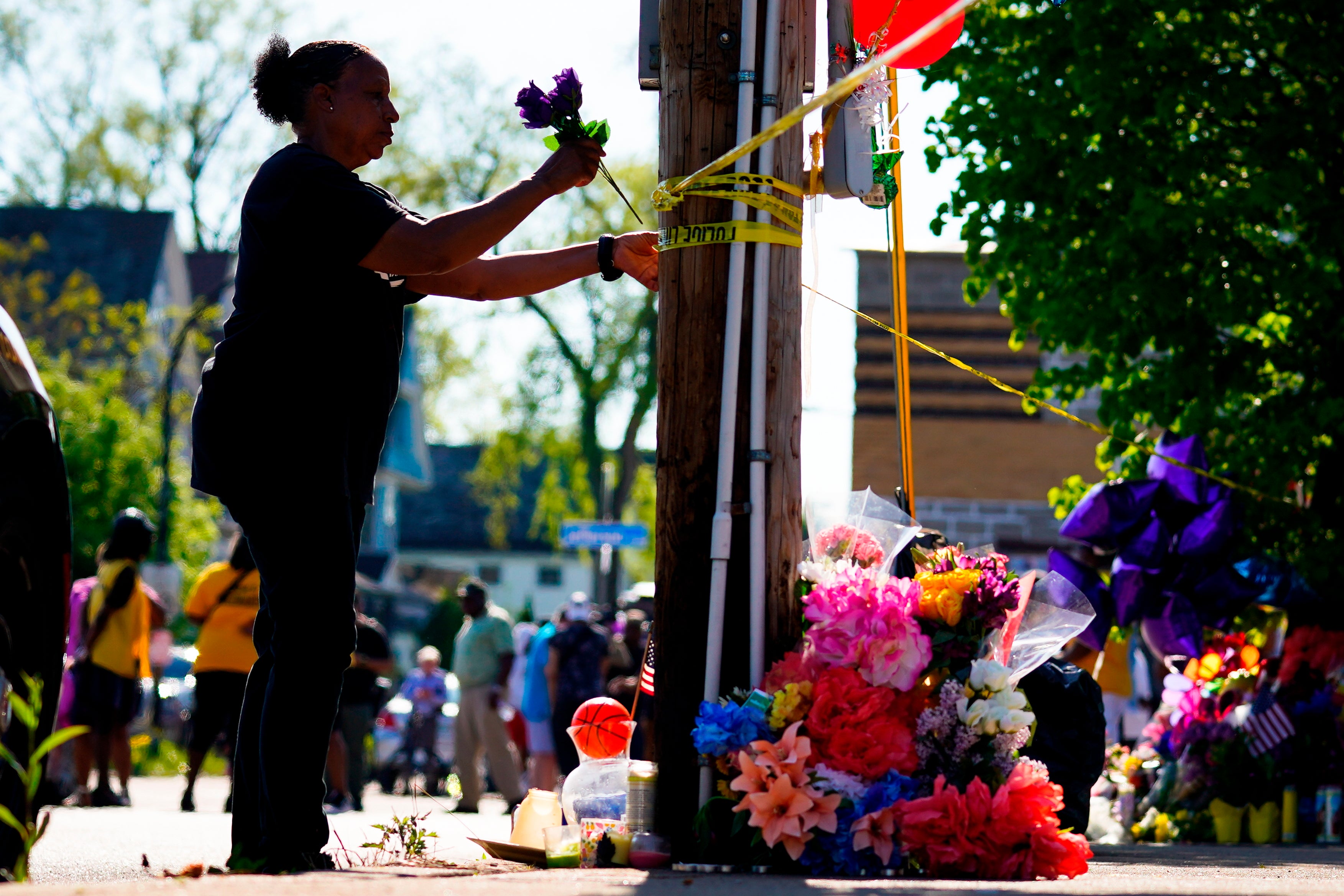 A person tends to a makeshift memorial outside the scene of shooting at a supermarket in Buffalo on 15 May