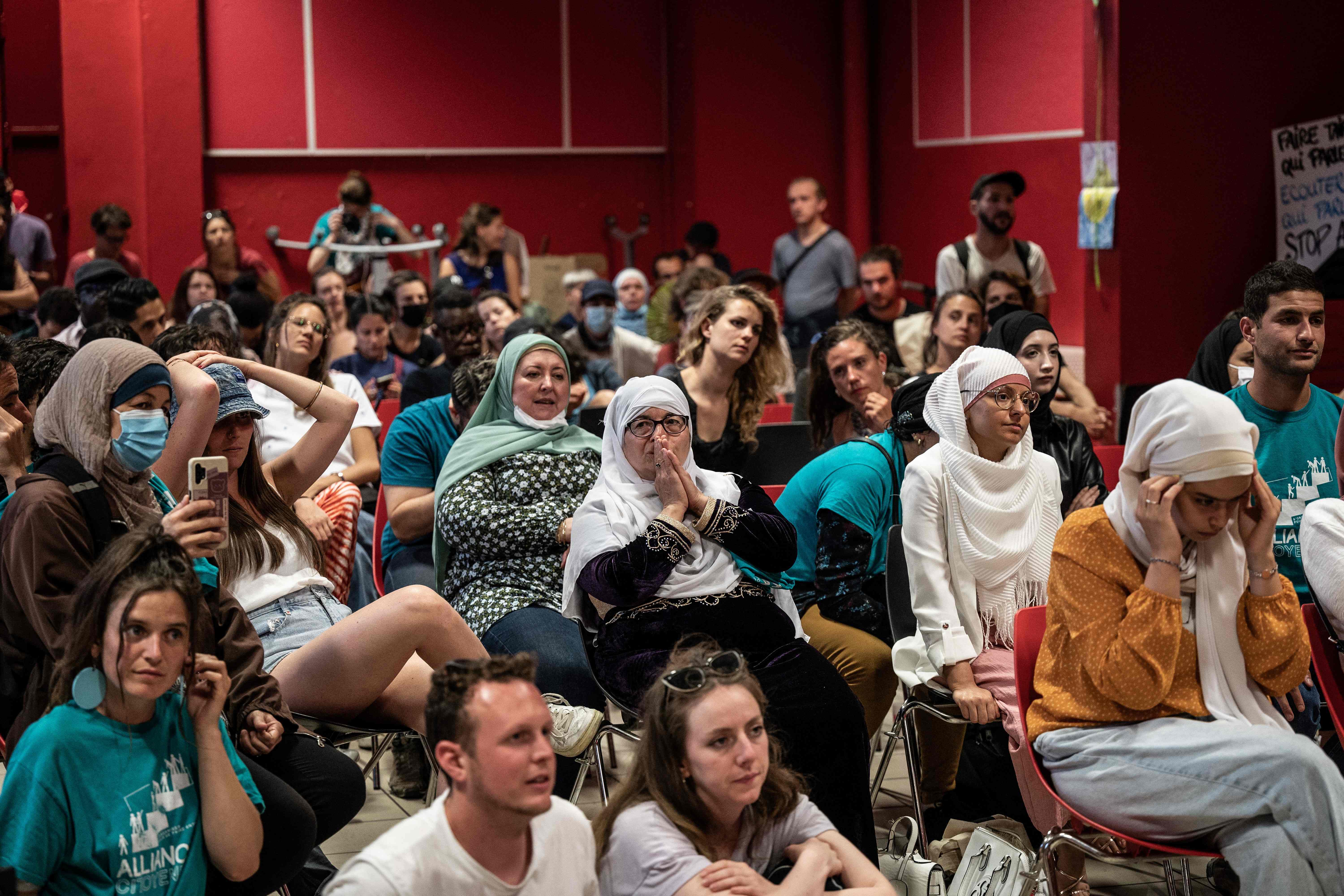 Members of a pro-burkini association watch TV showing members of the municipal council vote to allow burkinis in swimming pools in Grenoble on 16 May