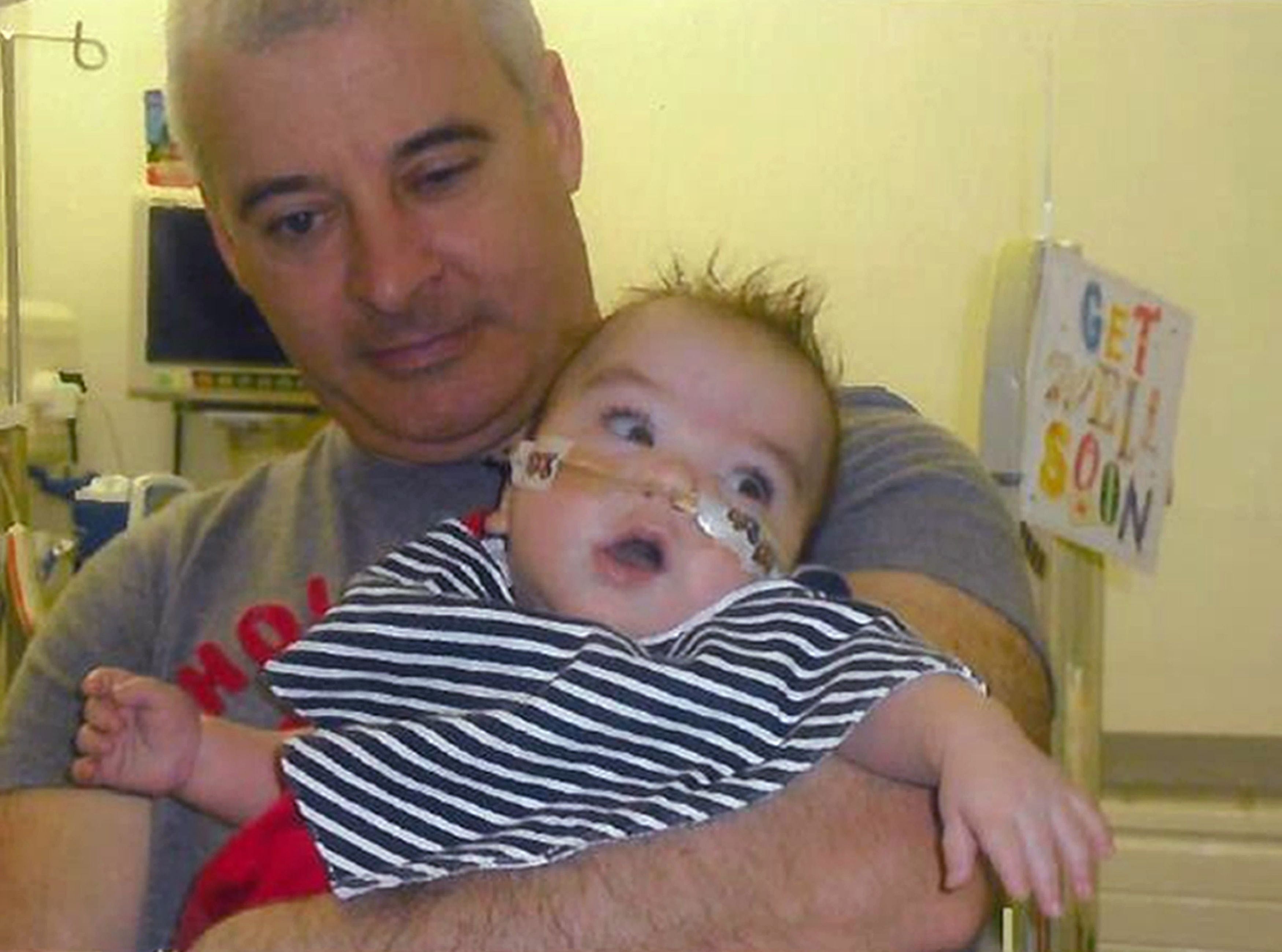 Undated family handout file photo issued by PSNI of fatally shot Kevin McGuigan with his grandson Ollie, who was in hospital in 2011, as a woman has been arrested by police investigating his murder.