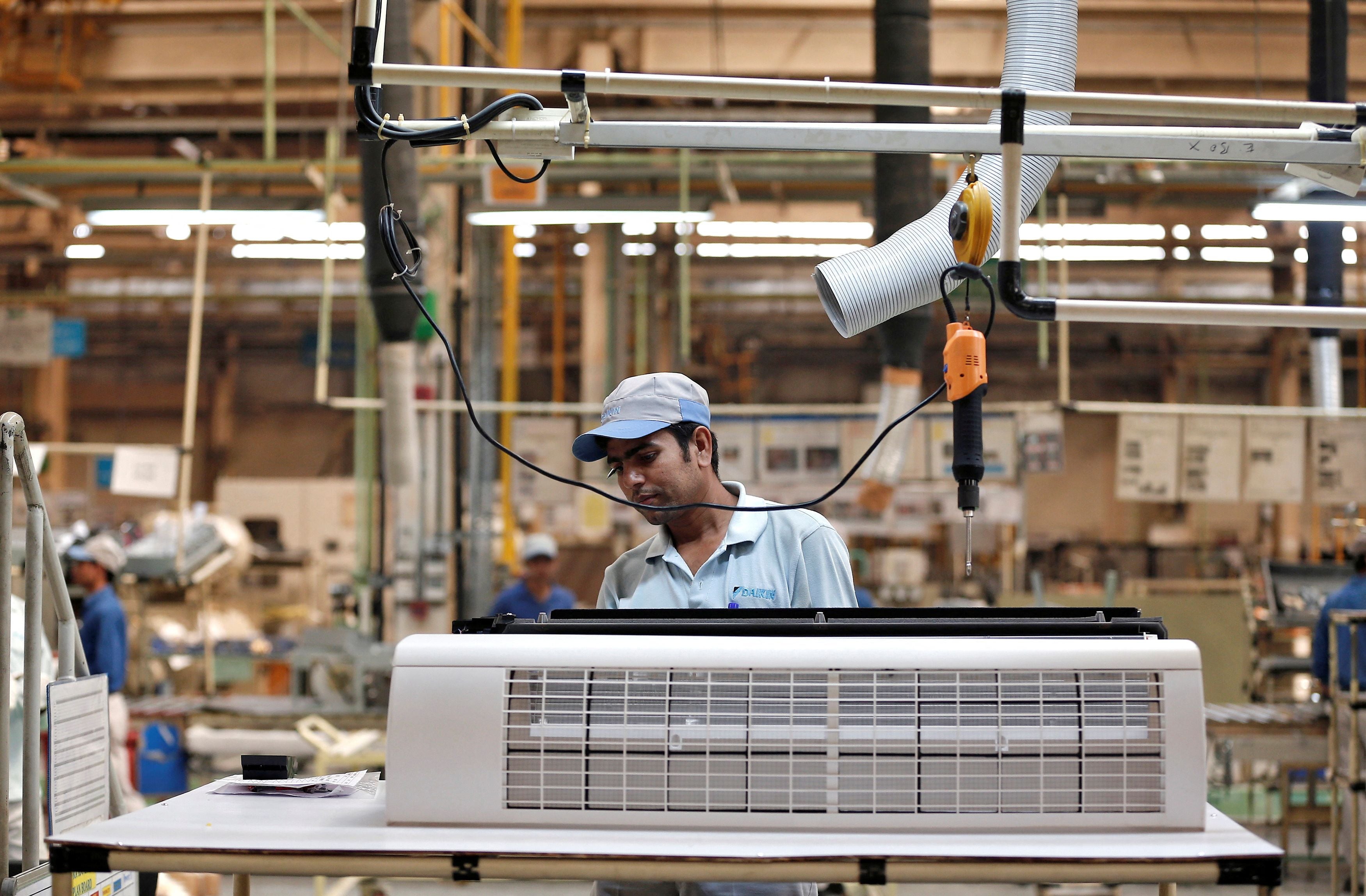 File. A worker assembles an air conditioner in a Daikin Industries plant at Neemrana in the Indian state of Rajasthan on 1 October 2014