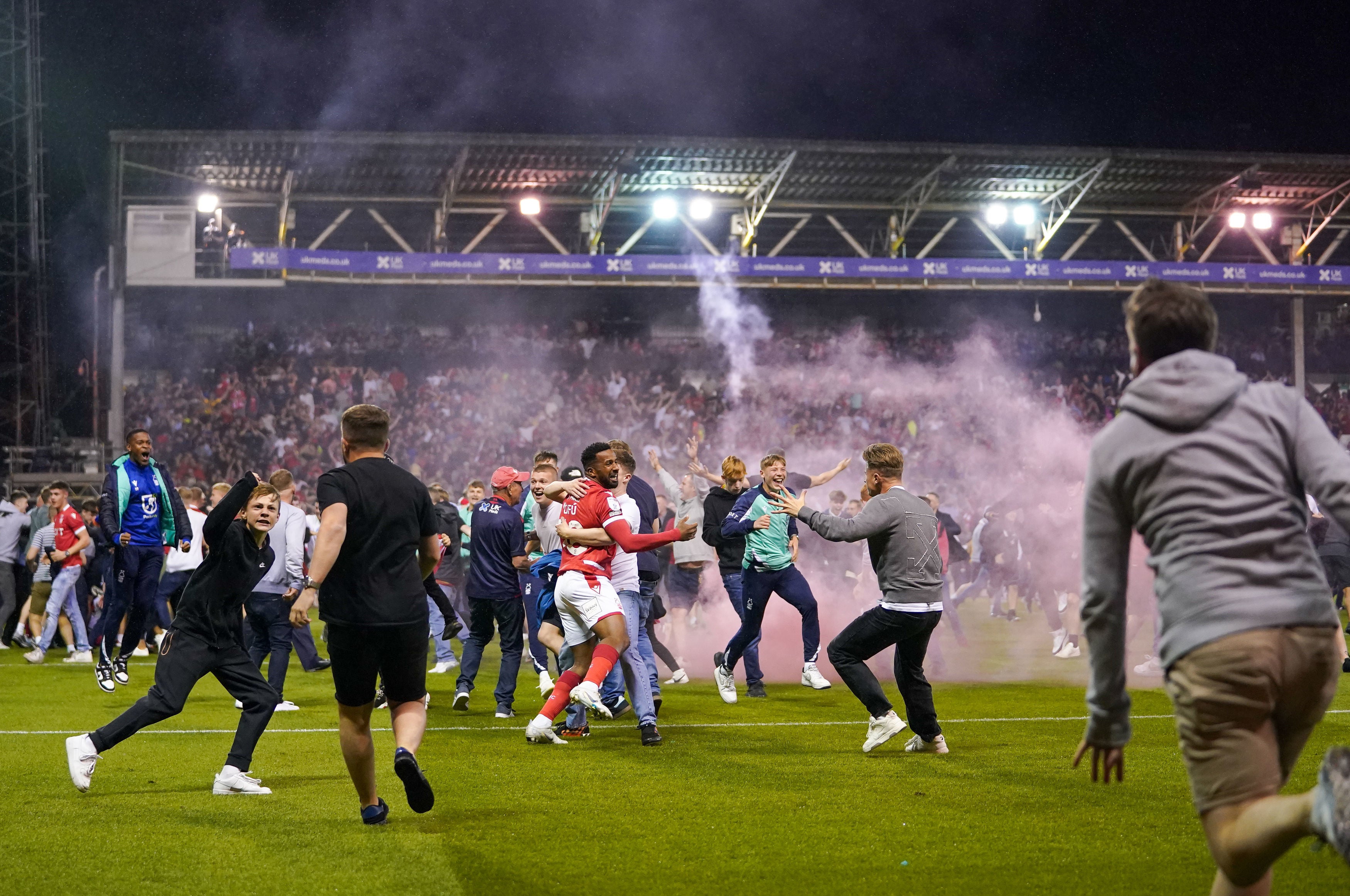 Nottingham Forest fans run onto the City Ground pitch after the home team’s victory on penalties