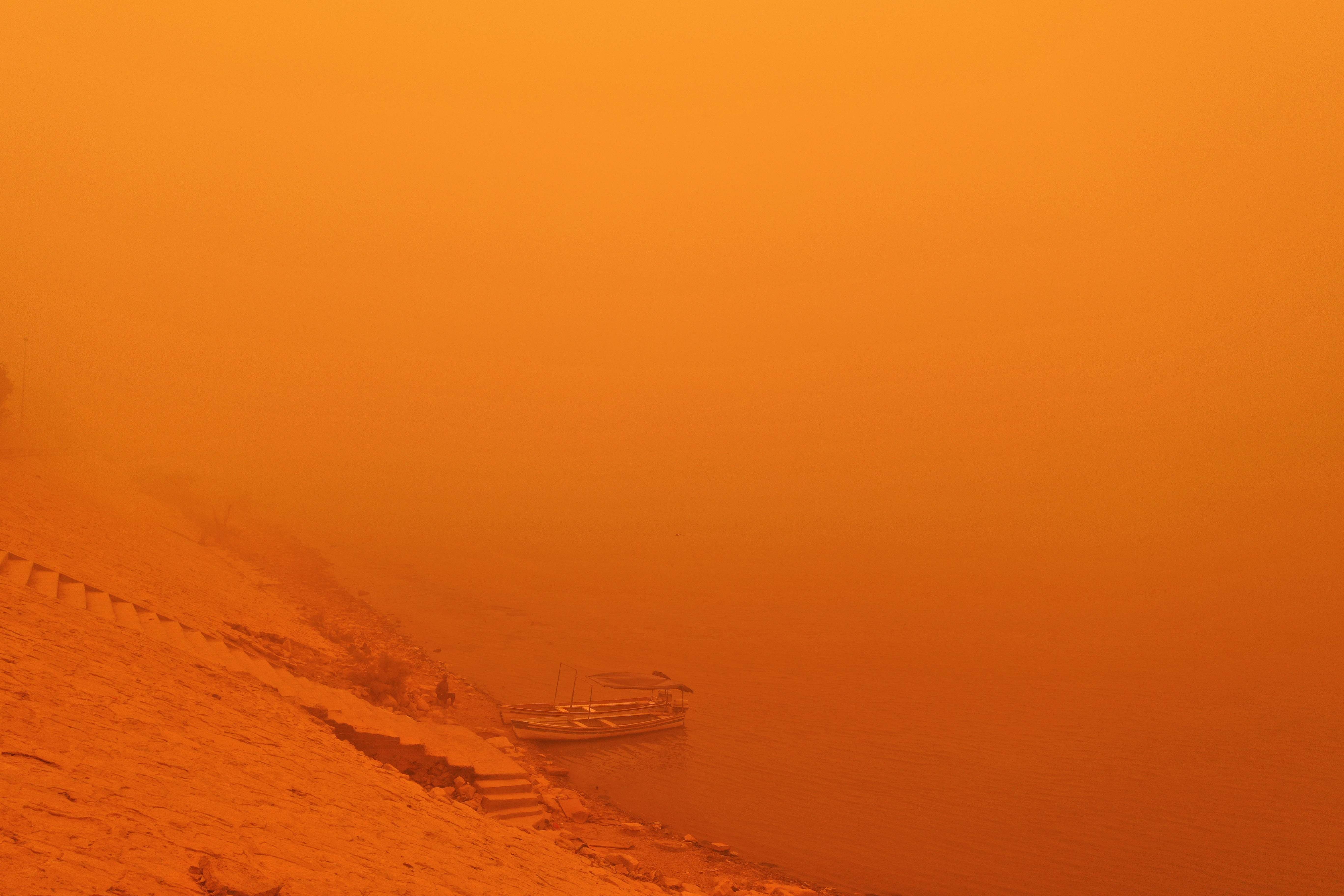 This picture taken on 16 May 2022 shows a view of the Tigris river bank in Iraq’s capital Baghdad amidst a heavy dust storm