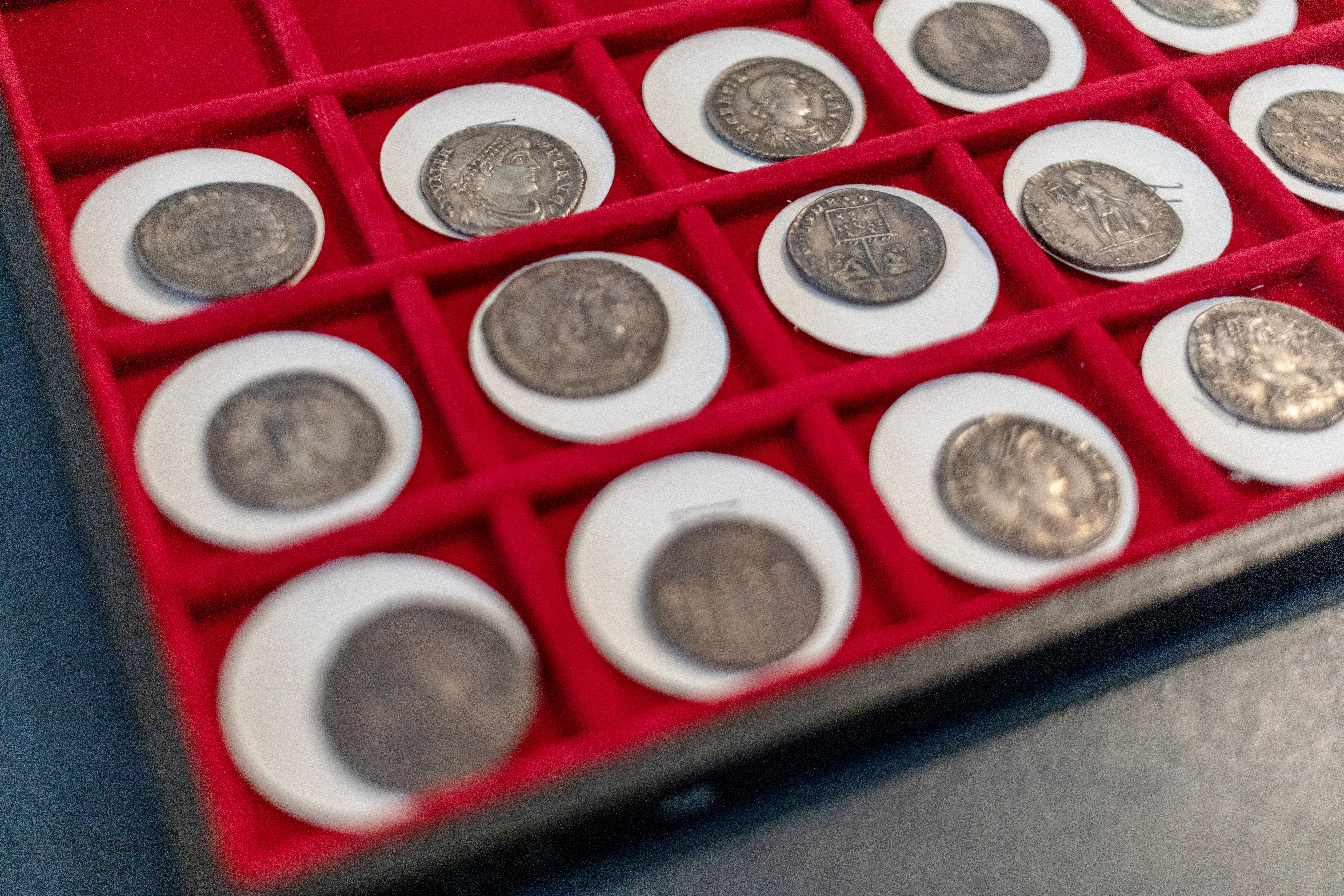 A selection of old Roman coins in a display case, found in Pewsey Vale, Wiltshire