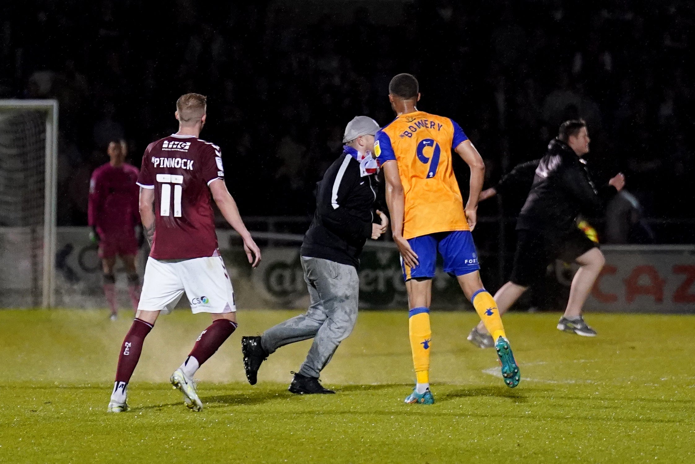 Mansfield’s Jordan Bowery and a pitch invader during the League Two play-off semi-final, second leg at Northampton (Tim Goode/PA)