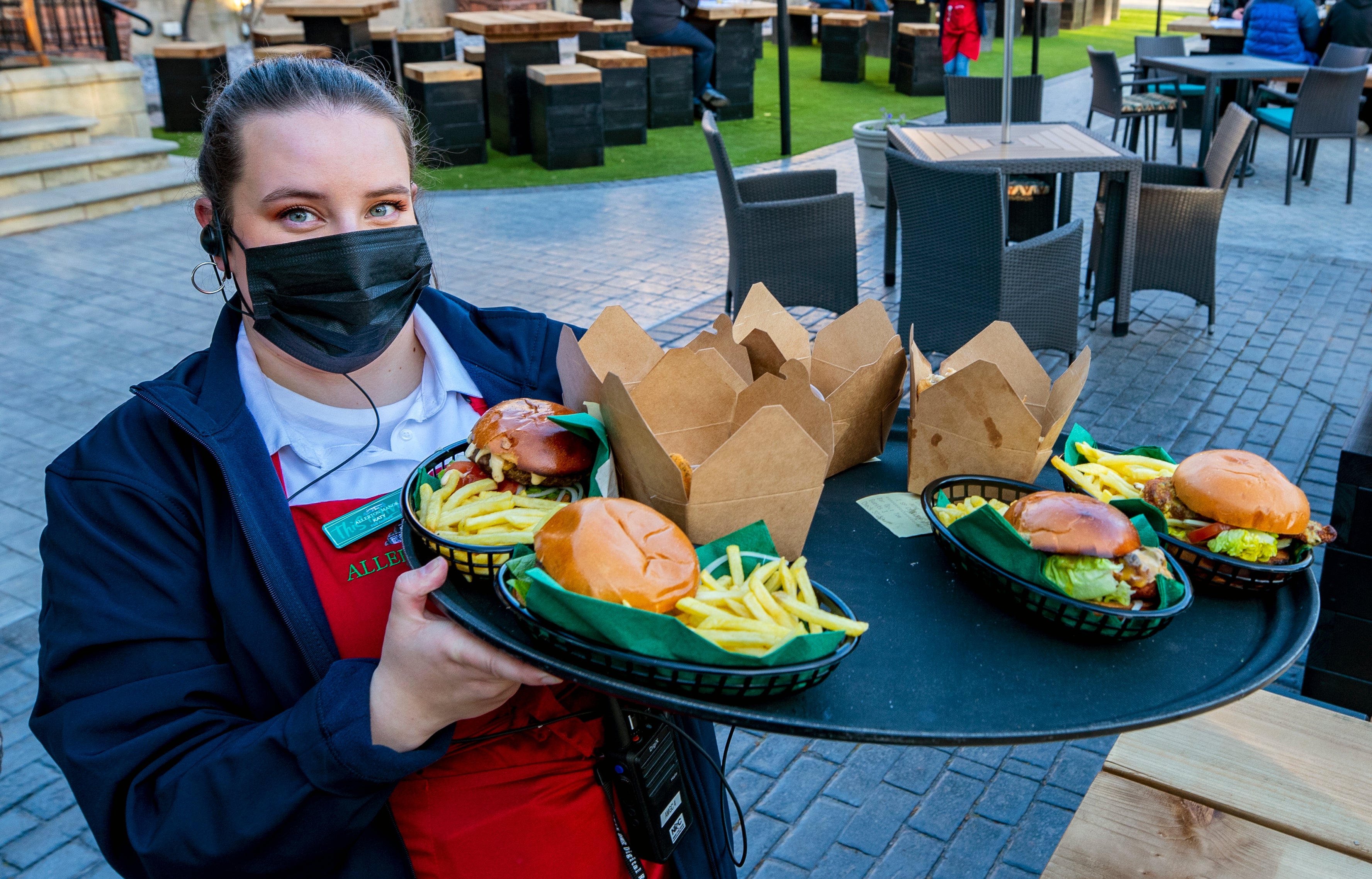 A member of staff carries a tray of food at Allerton Manor golf course in Liverpool (Peter Byrne/PA)