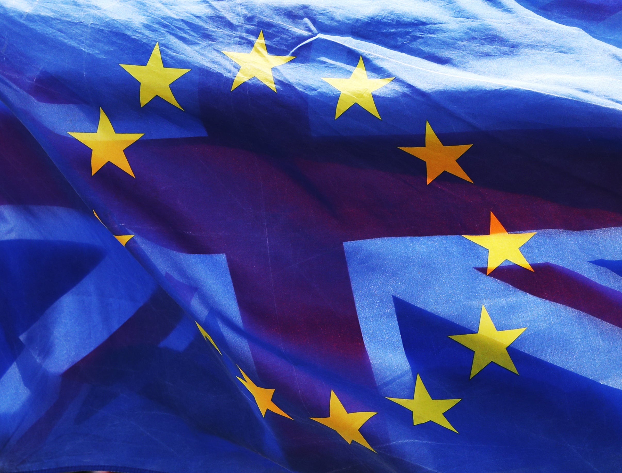 Flags of the European Union and Great Britain fly together on College Green near the Palace of Westminster (PA)